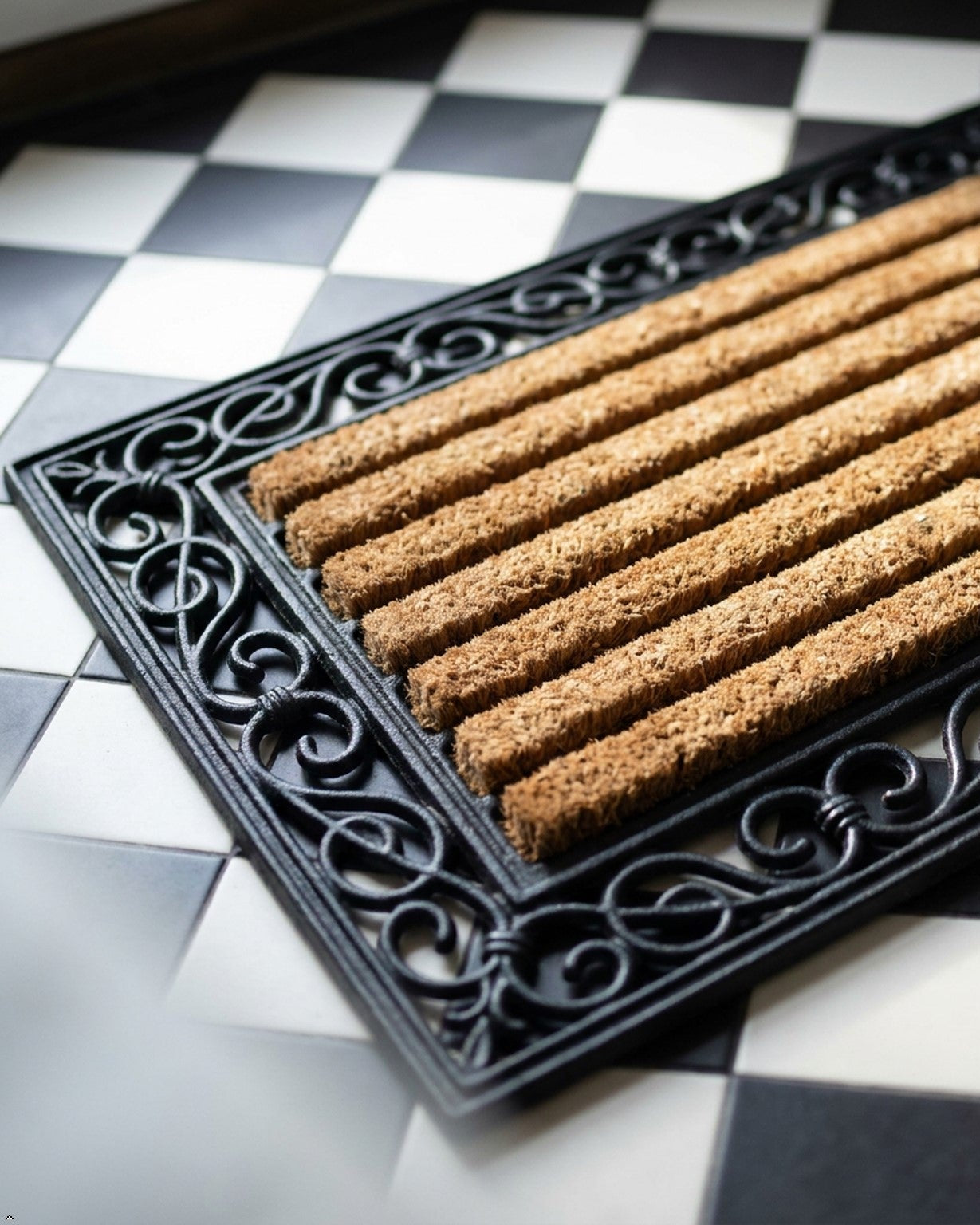 Doormat with decorative border on a checkered floor