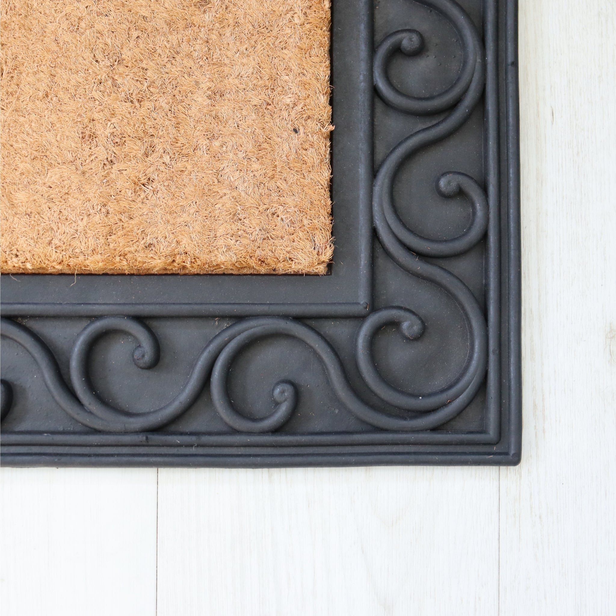 Doormat with decorative black border on a white floor