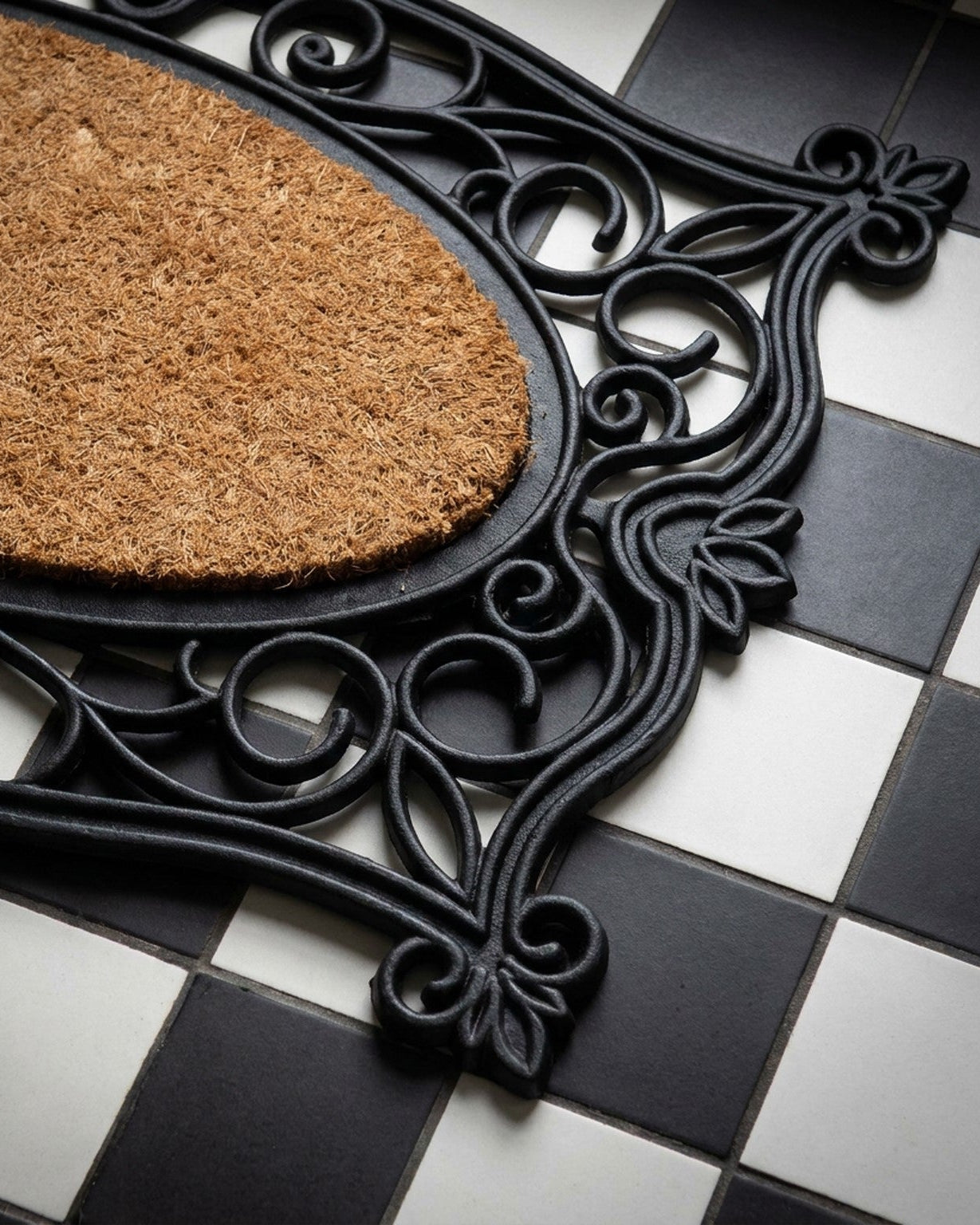 Decorative doormat with black metal frame on a checkered floor