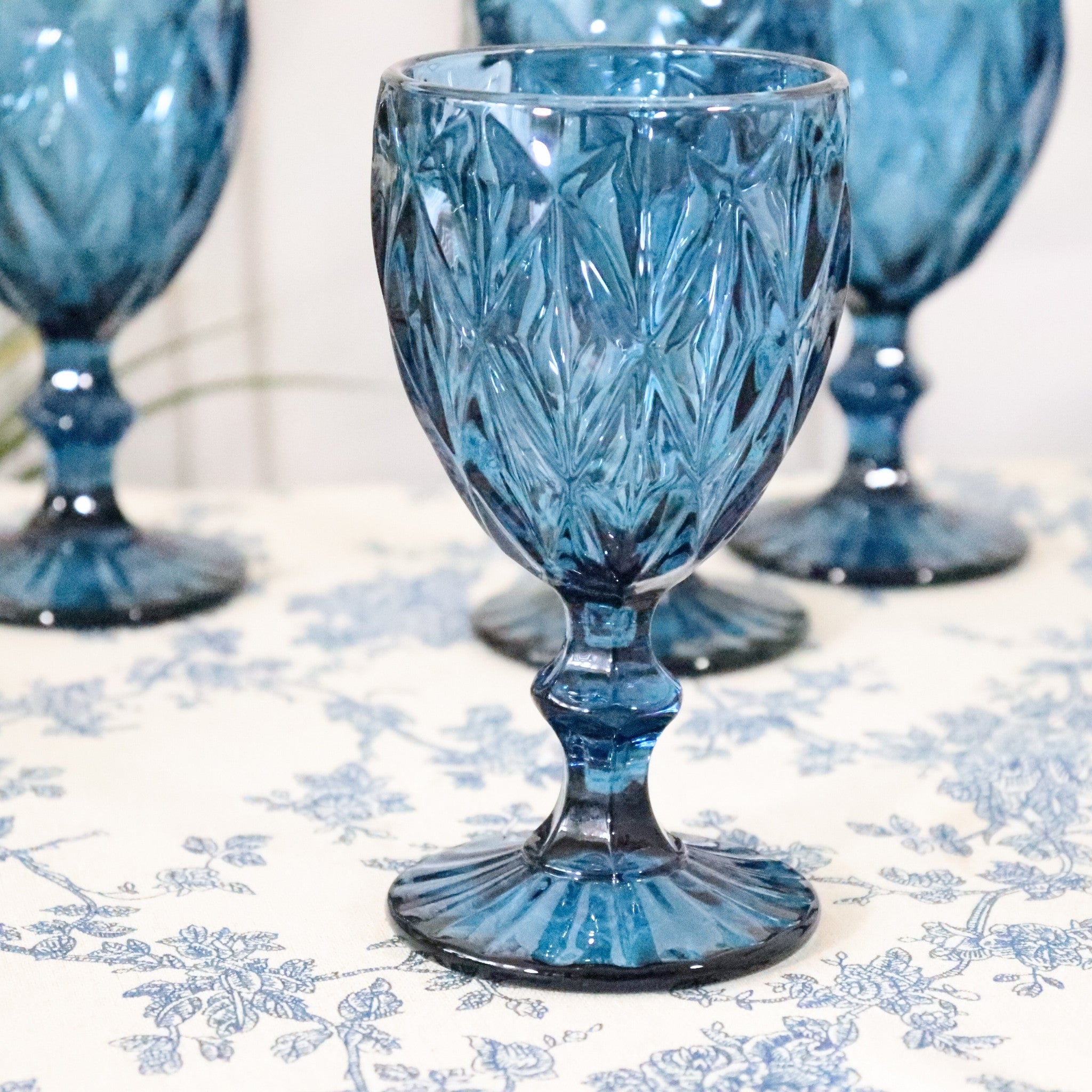 Blue crystal goblets on a floral tablecloth