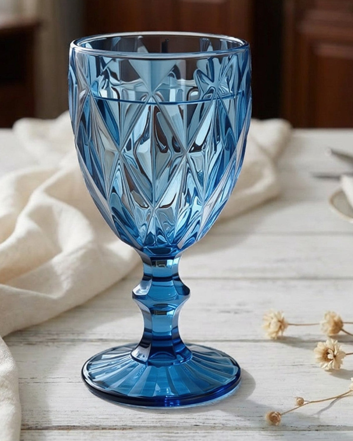 Blue glass goblet on a table with a neutral background