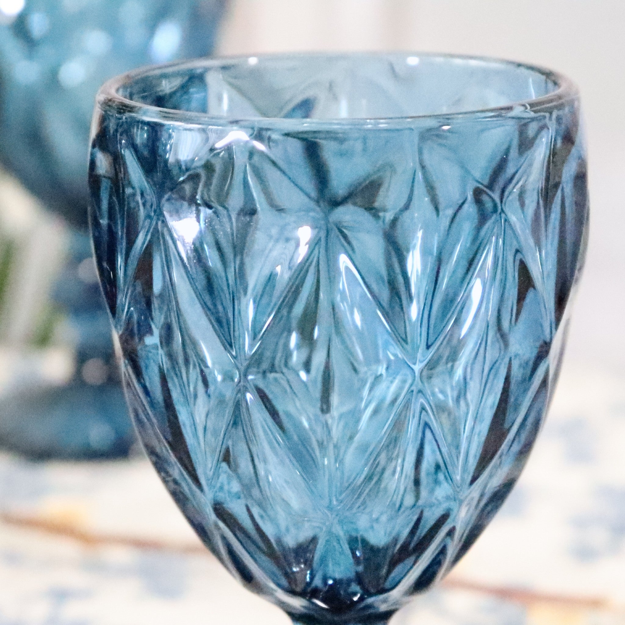 Blue glass with diamond pattern on a blurred background