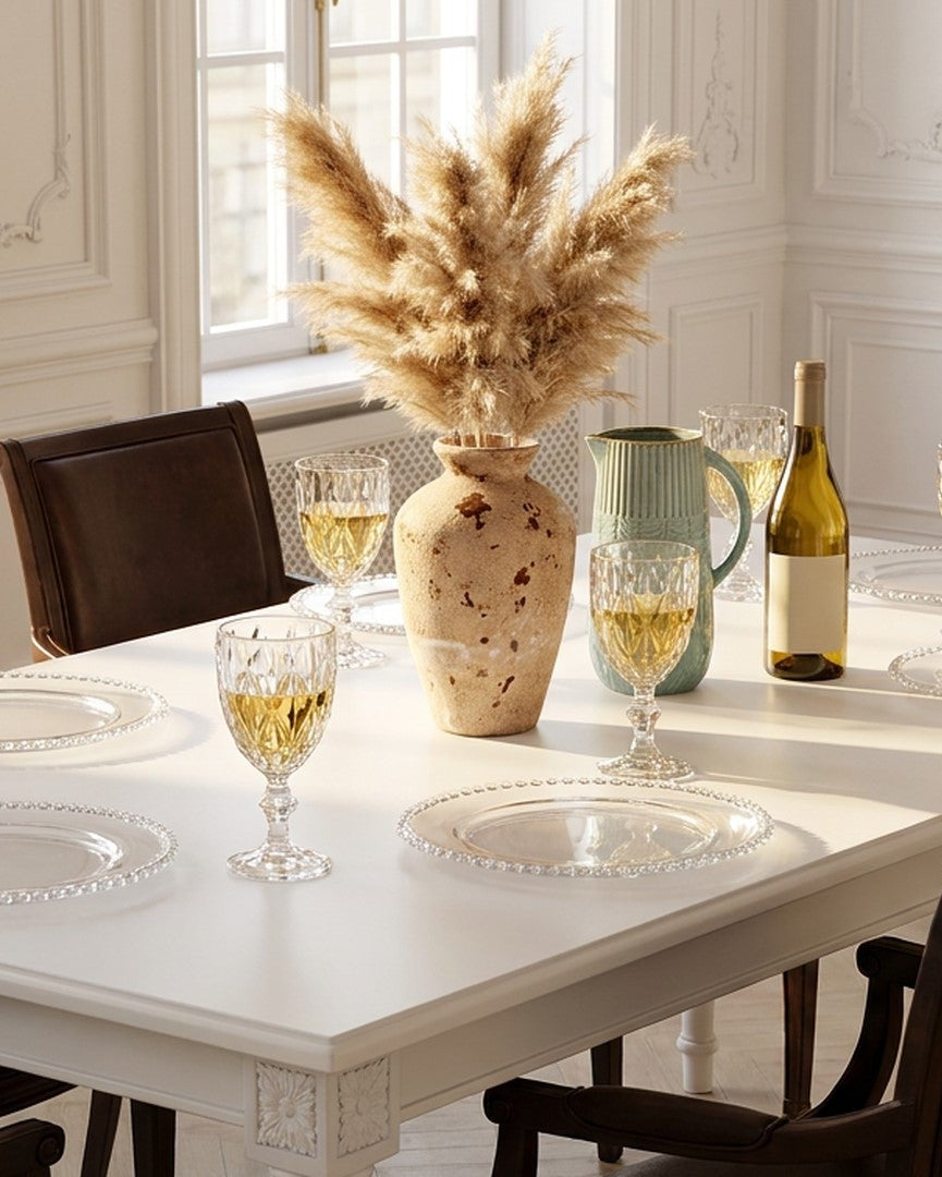 Dining room table set with wine glasses, a bottle, and decorative elements.