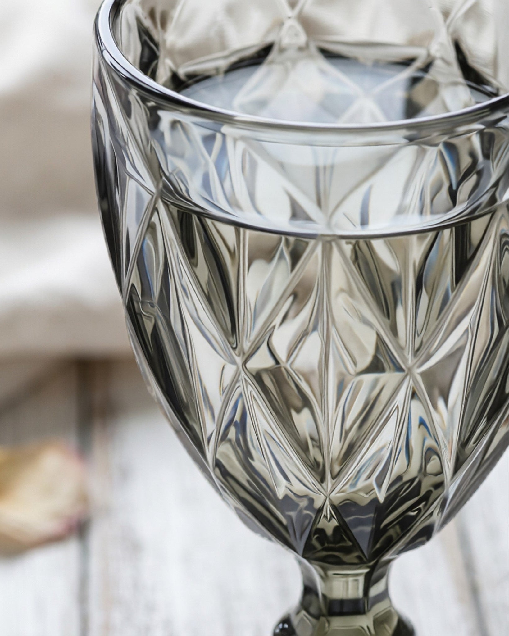 Crystal wine glass with diamond cut design on a blurred background