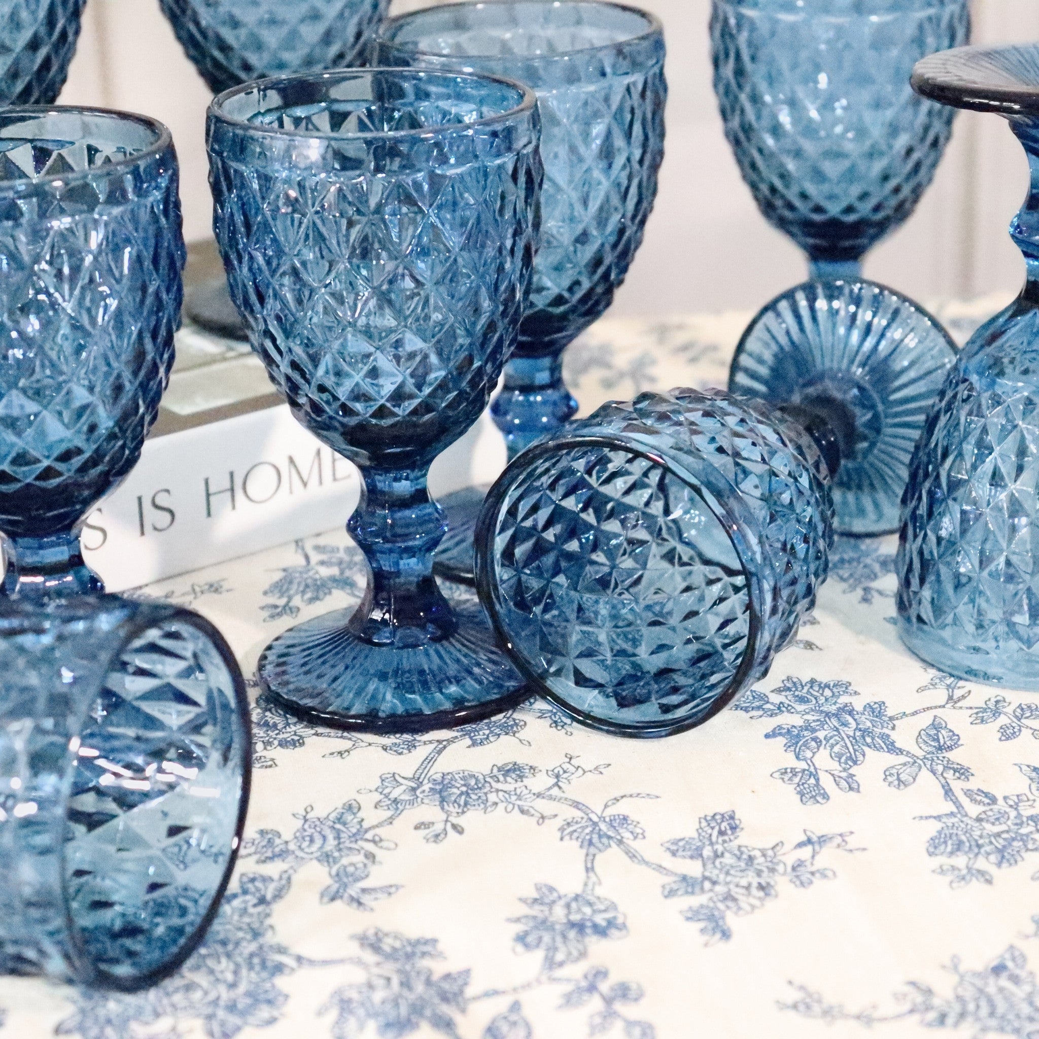 Blue glass goblets on a floral tablecloth
