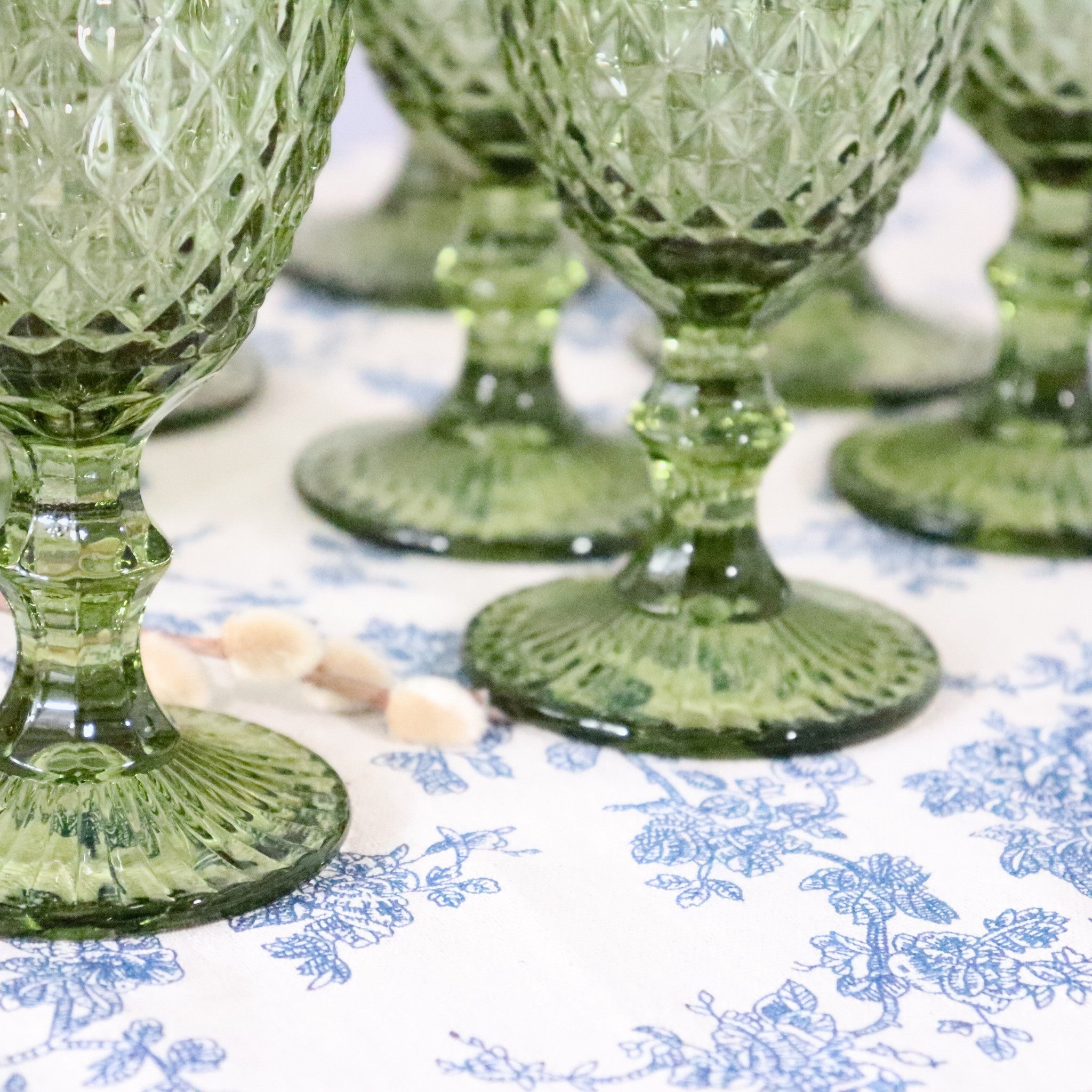 Green glass goblets on a patterned tablecloth