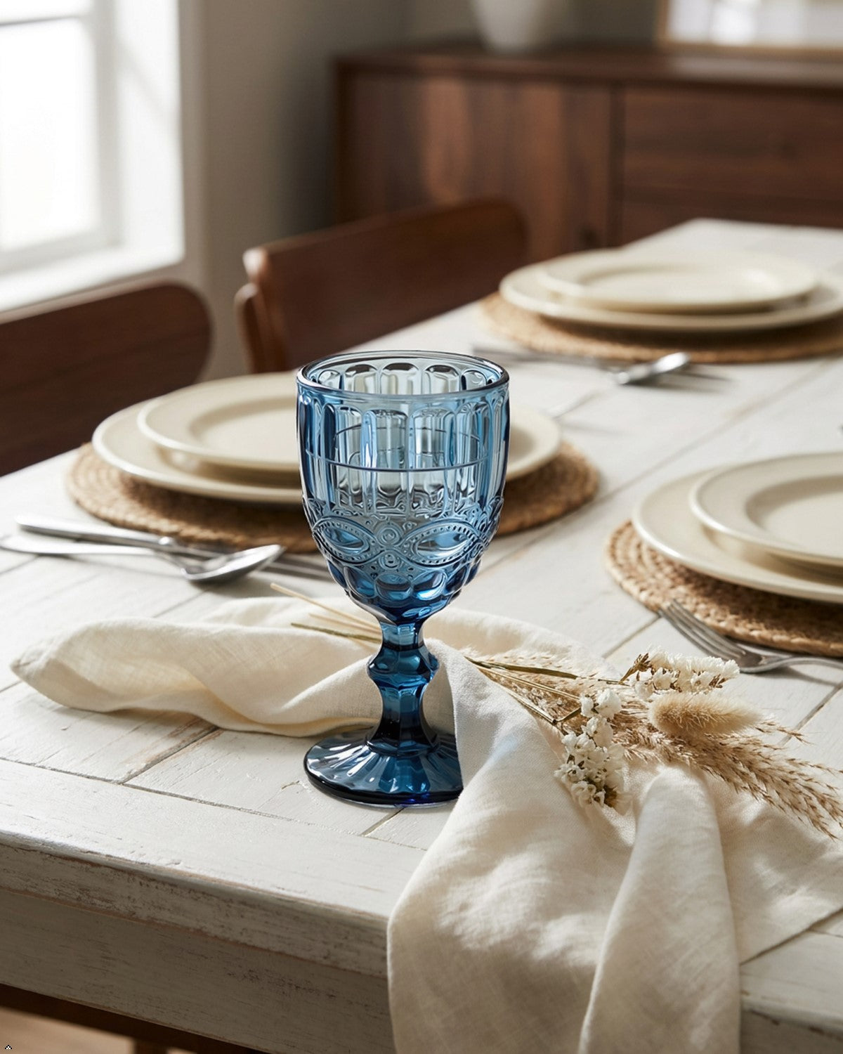 Blue glass goblet with intricate design on a blurred background