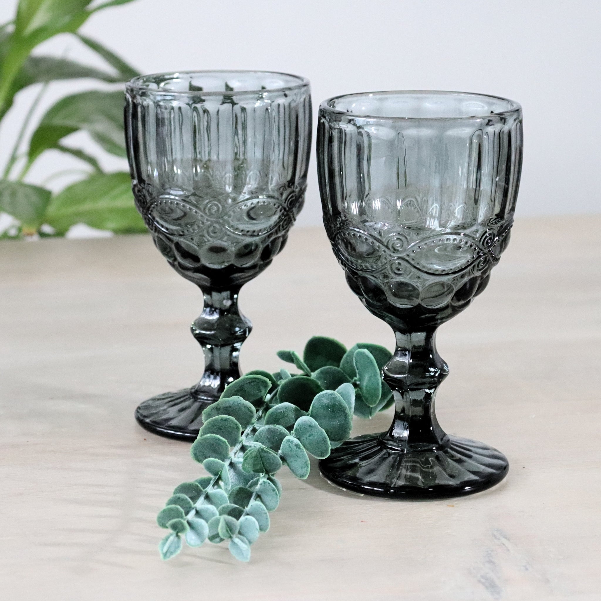 Grey glass goblet with intricate patterns on a white background