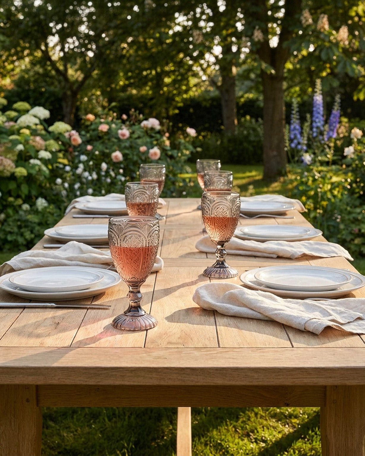 Set of grey glass goblets on a book with flowers and twine ball in the foreground