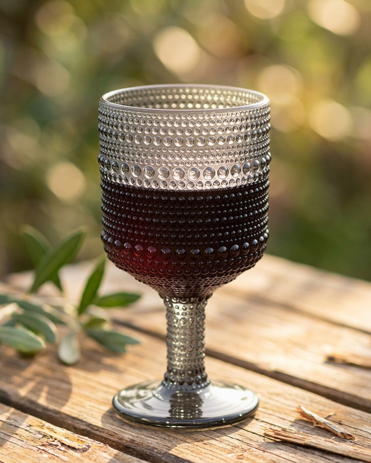 Set of green textured glassware on a wooden surface with a light wood panel background