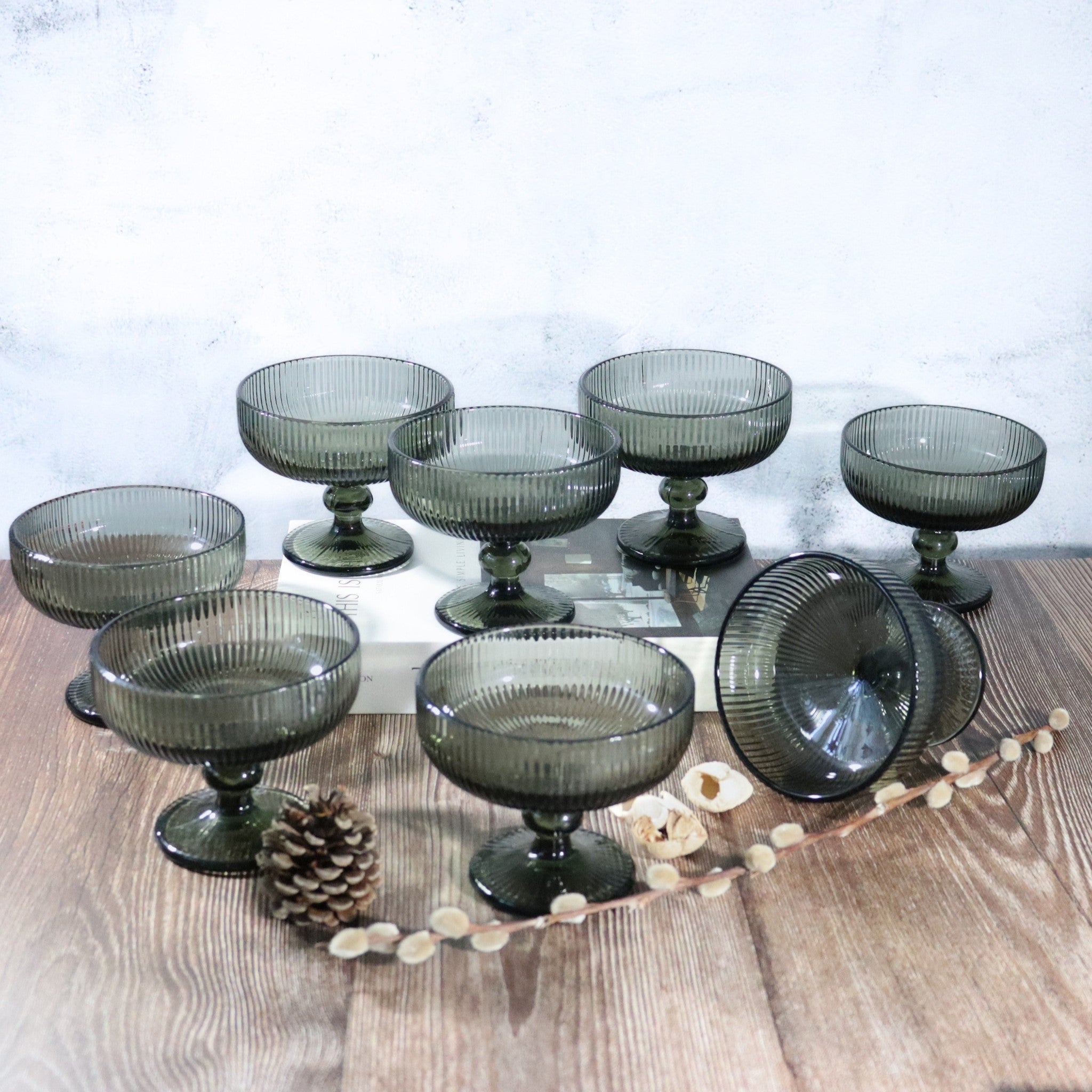 Set of smoked glass dessert bowls on a wooden surface with a white background