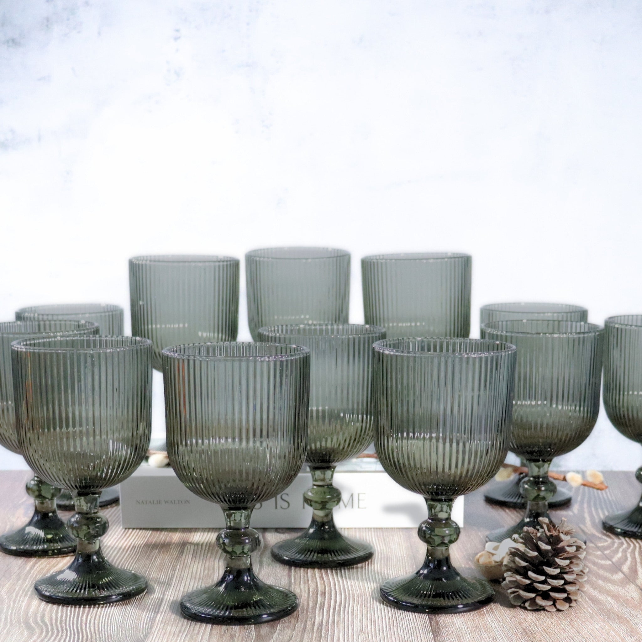 Set of ribbed glass goblets on a wooden surface with a white background