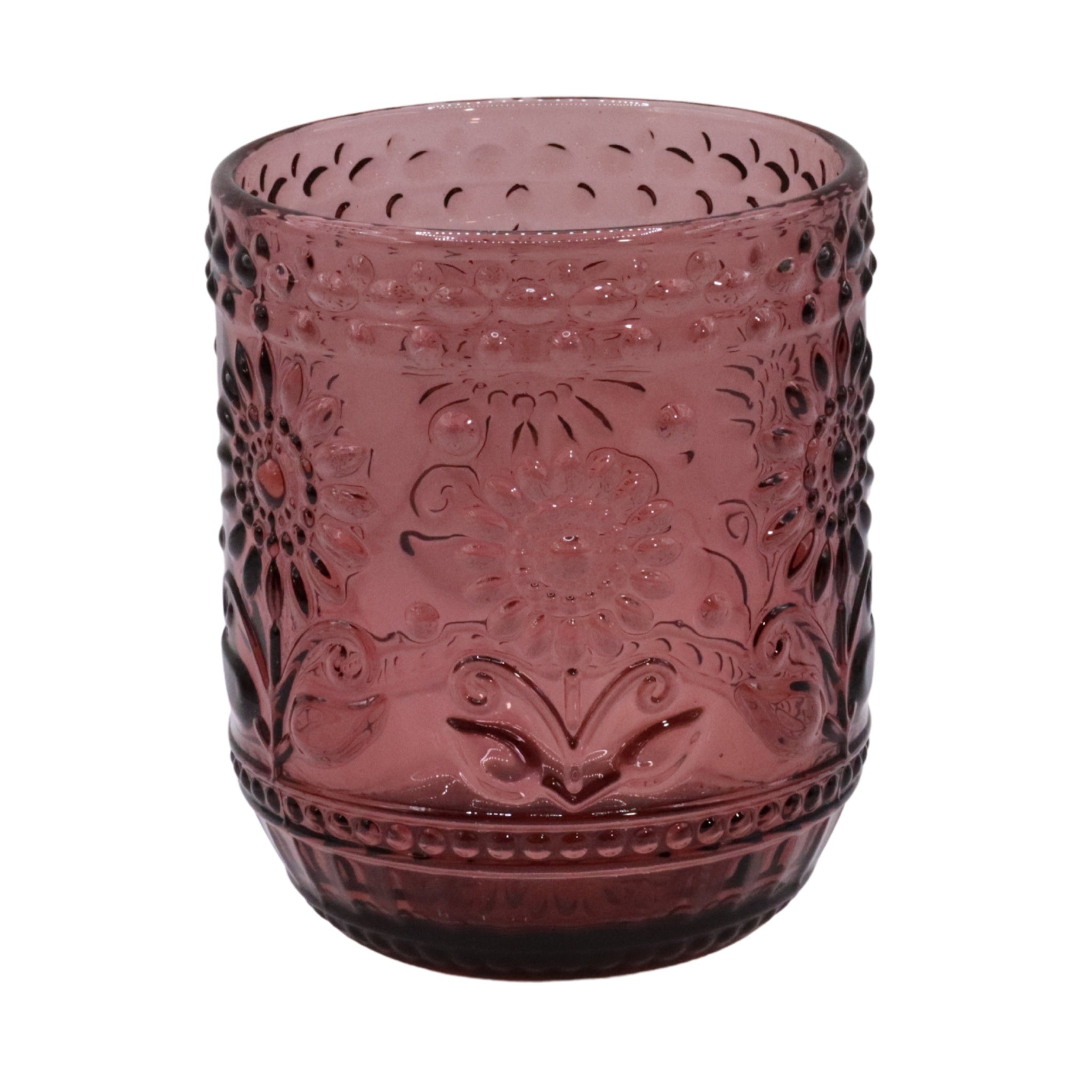Pink glass tumbler with intricate patterns on a white background
