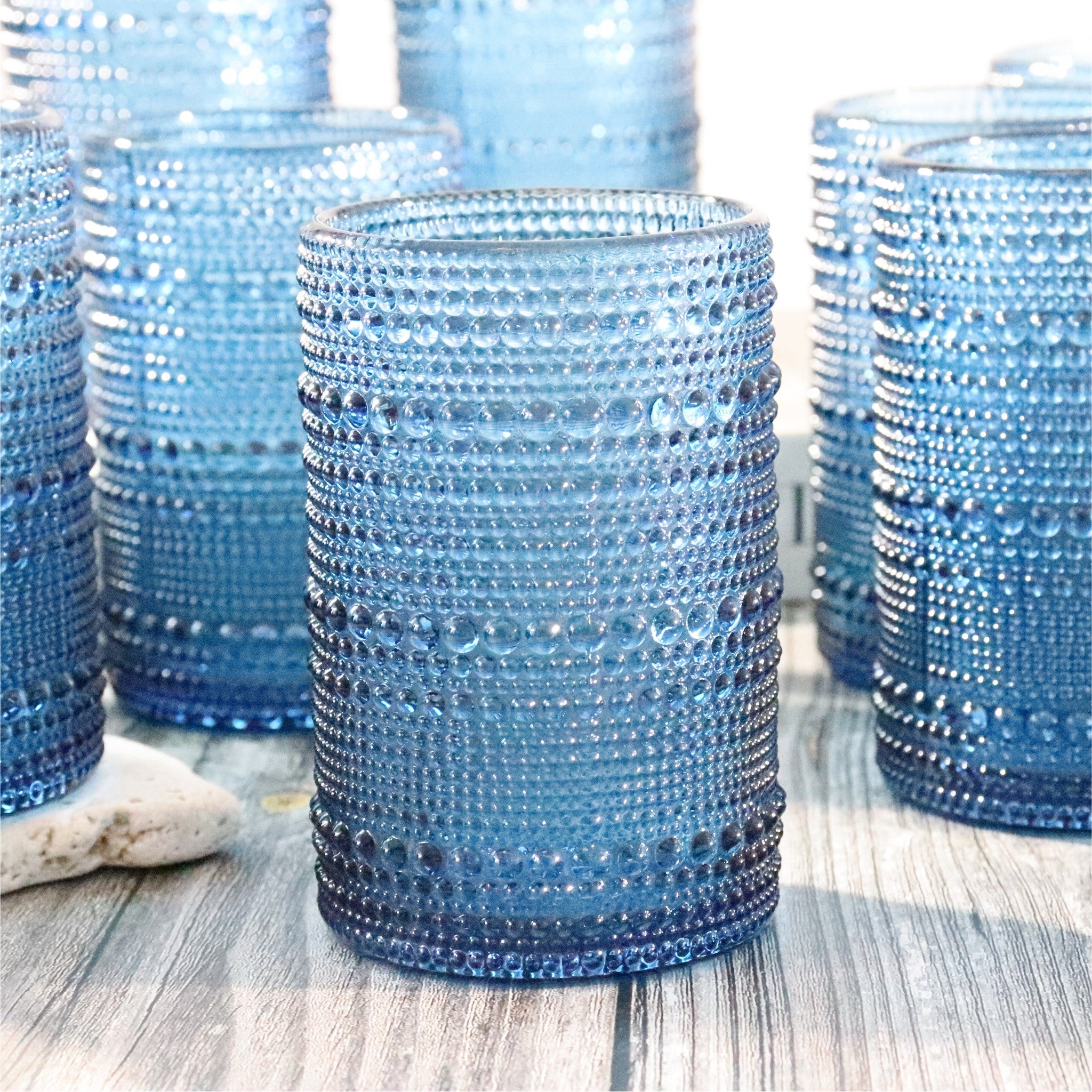 Blue textured glass tumblers on a wooden surface