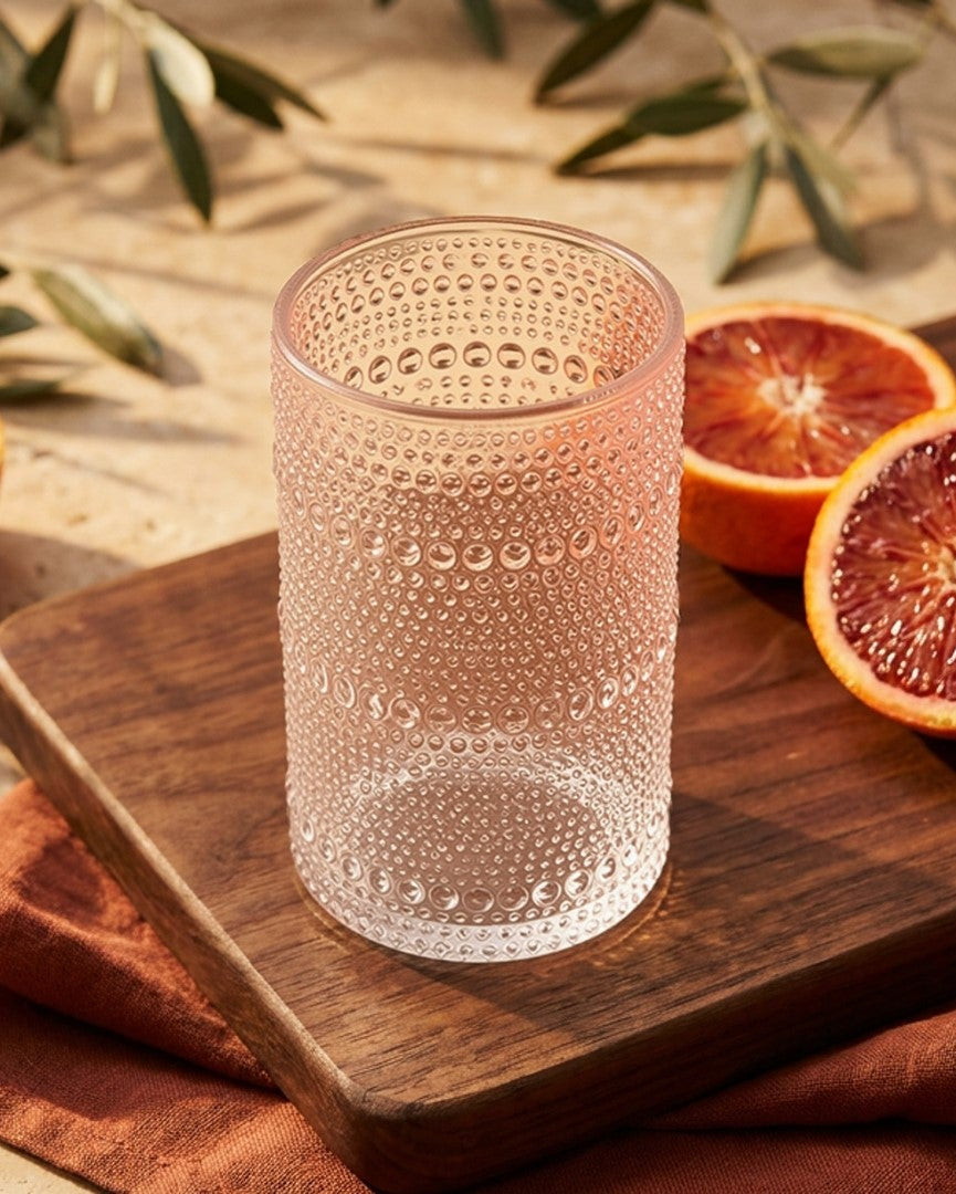 Set of textured glass tumblers on a wooden surface with a marble background