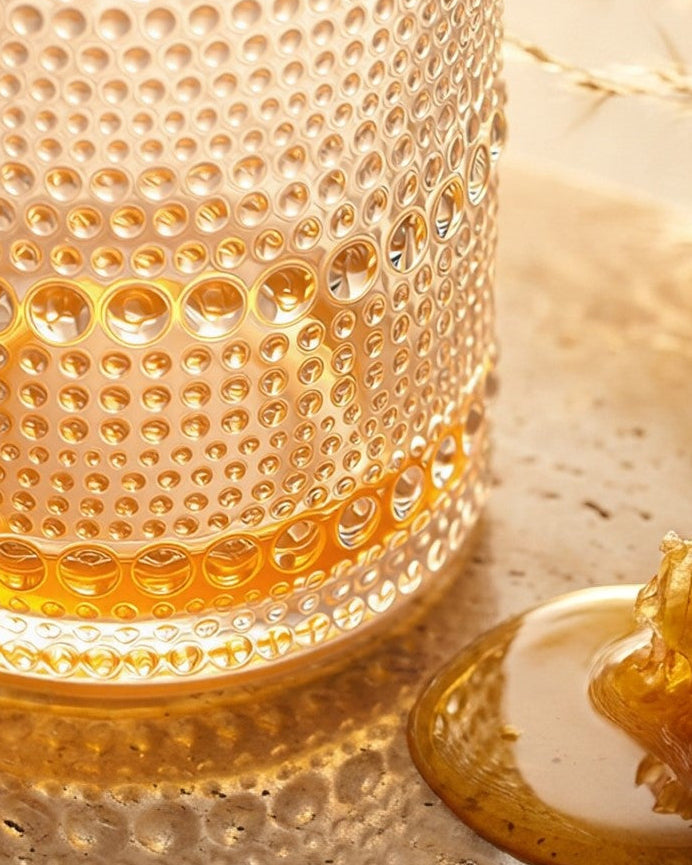 Set of textured glass tumblers on a wooden surface with a neutral background