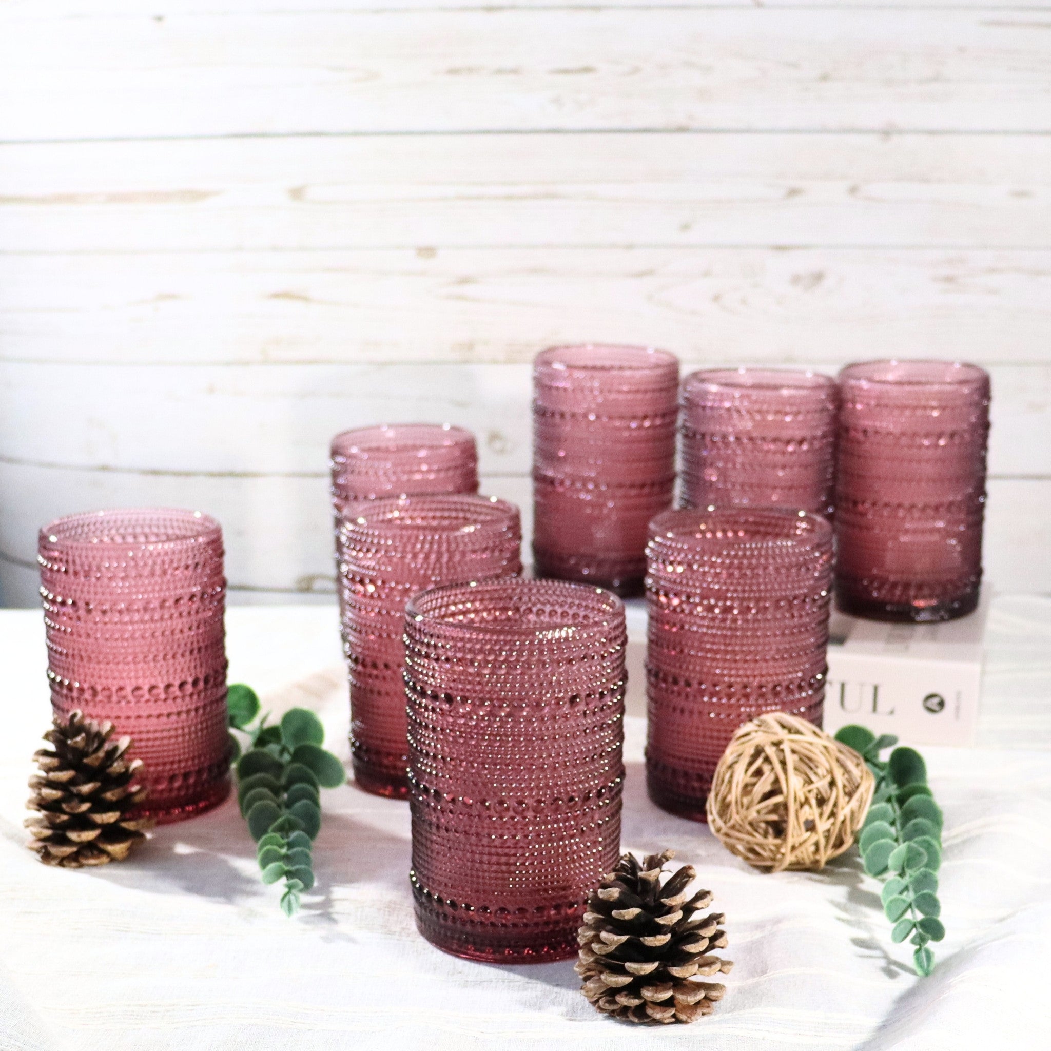 Set of pink beaded glasses on a white surface with decorative elements.