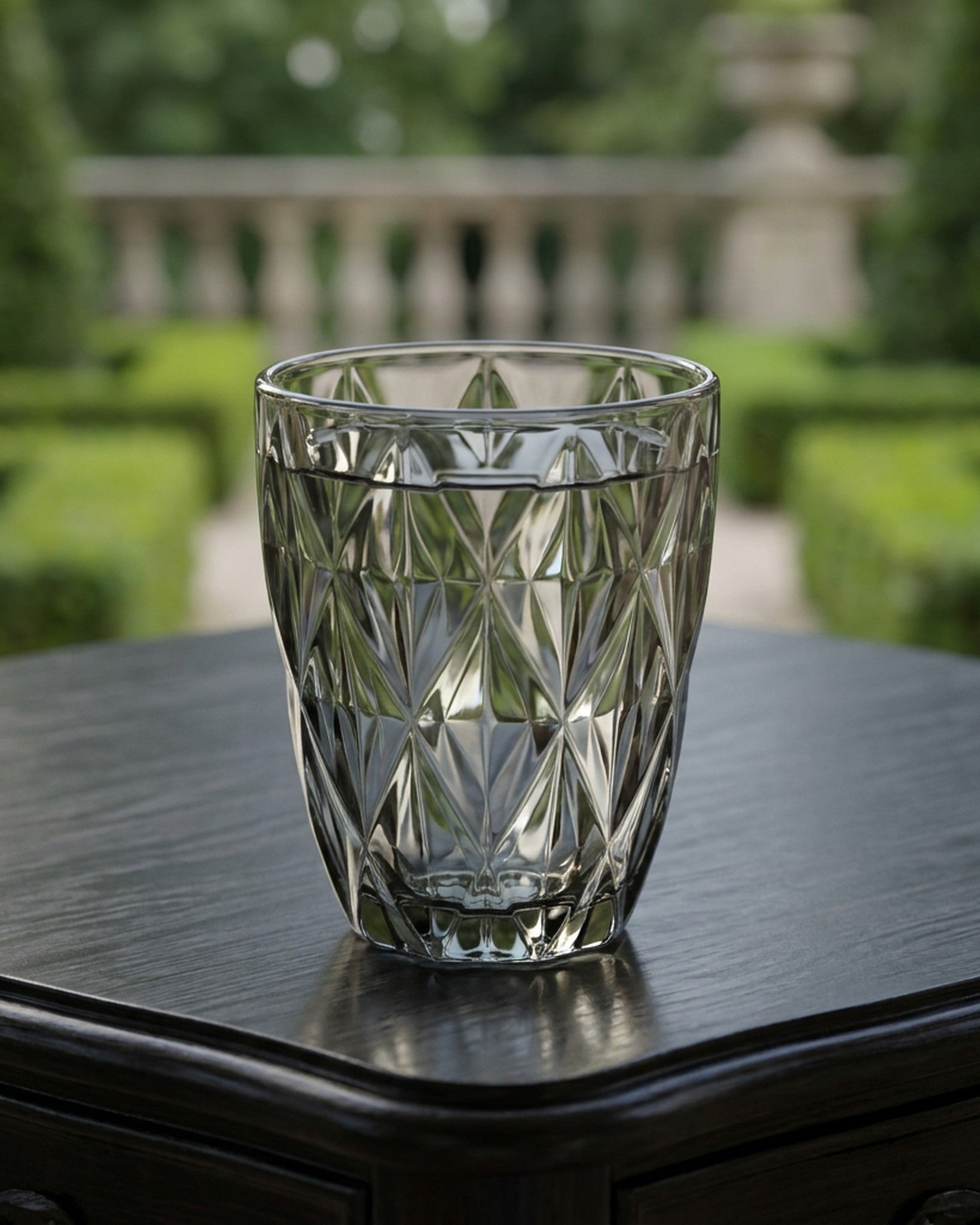 gray glass tumblers on a black surface with a blurred green background