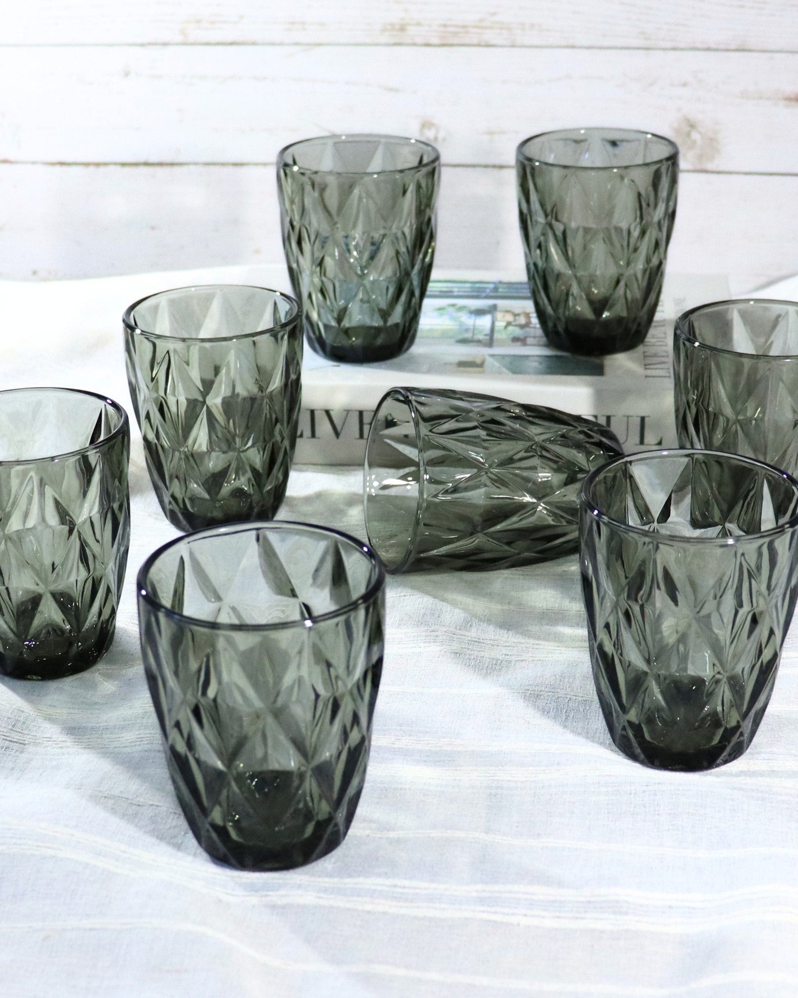 Set of smoked glass tumblers on a white wooden surface