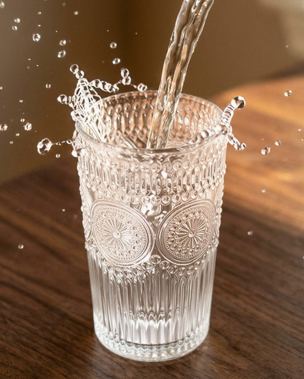 Set of clear glass tumblers on a wooden surface with a neutral background
