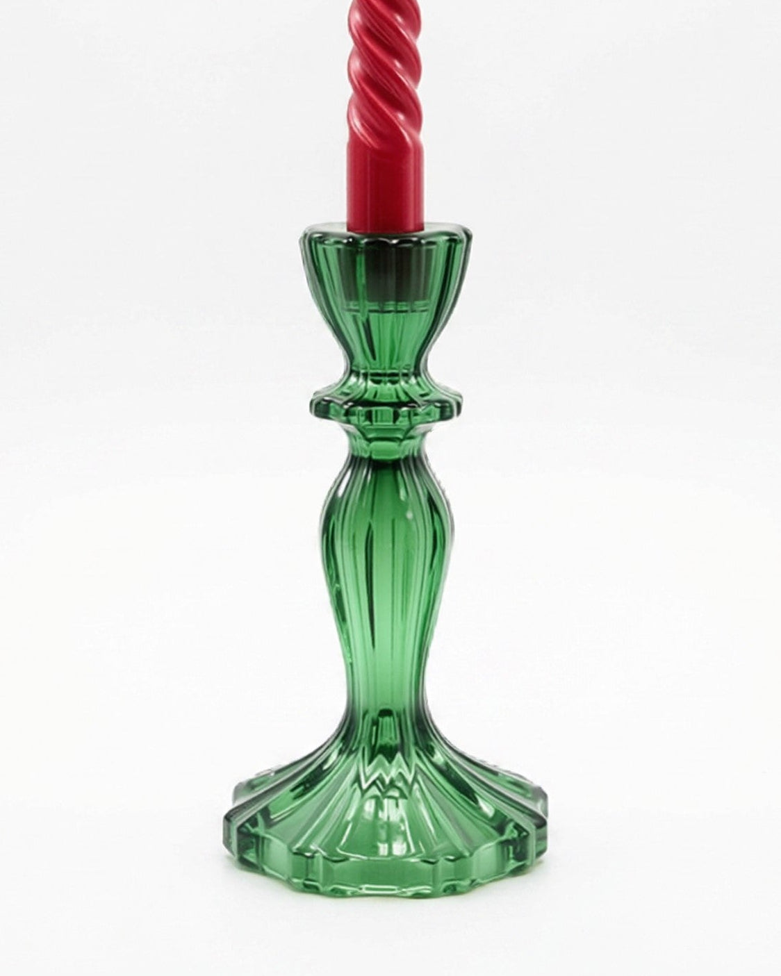 Green candle holder with a red candle on a white background