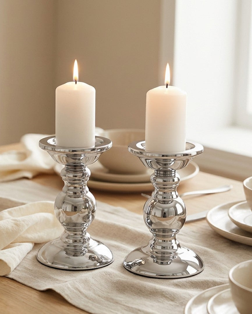 Dining table set with candles and a bow, in a softly lit room.