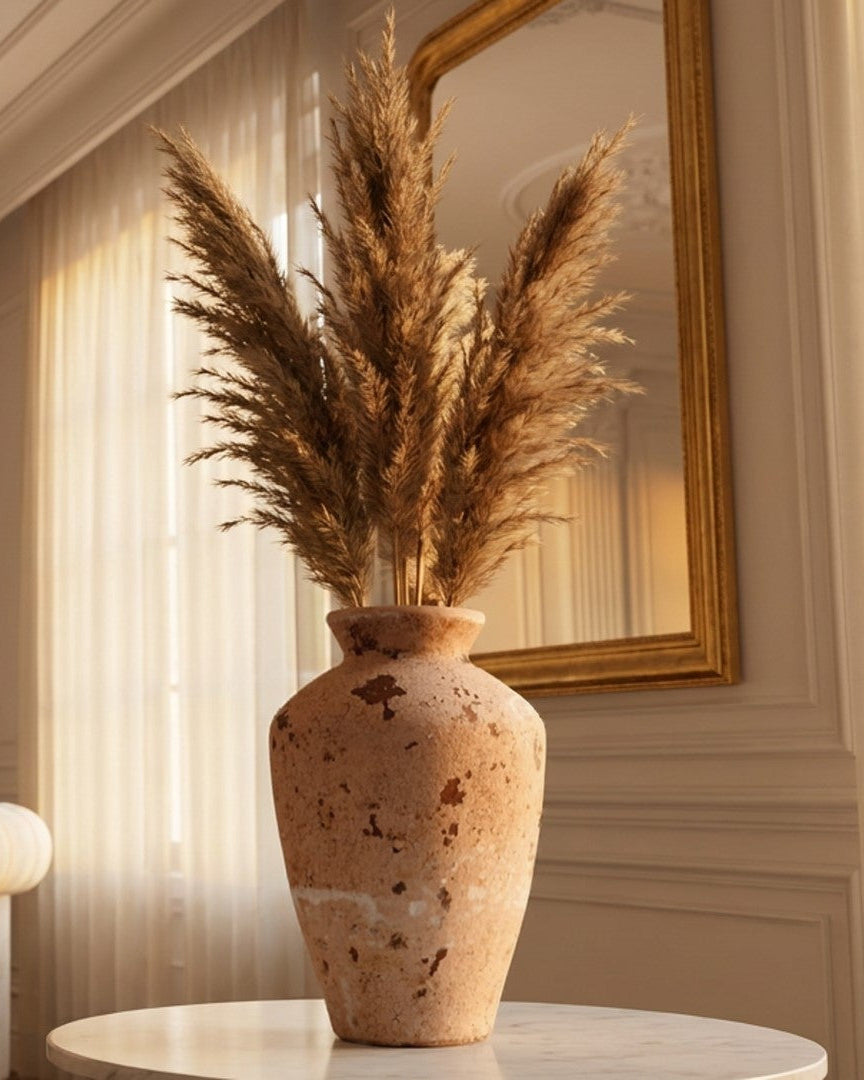 Decorative vase with dried pampas grass in a stylish room with a chair and mirror.