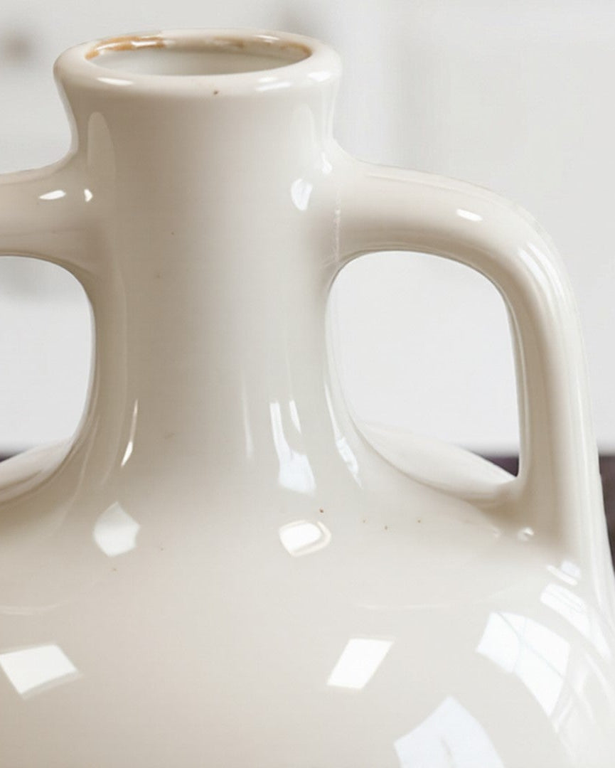White ceramic vase on a marble surface with a blurred background