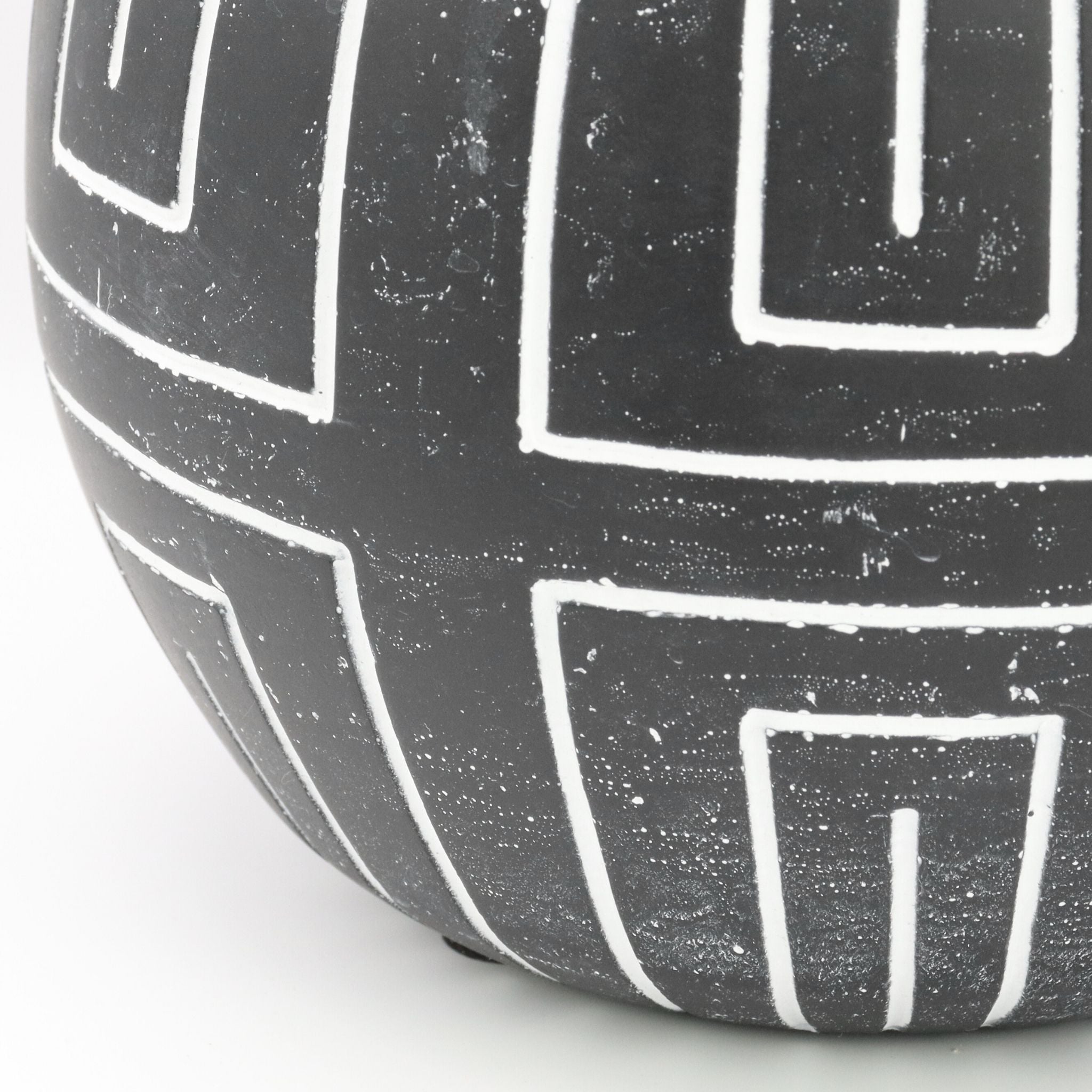 Black ceramic vase with white geometric patterns on a light background