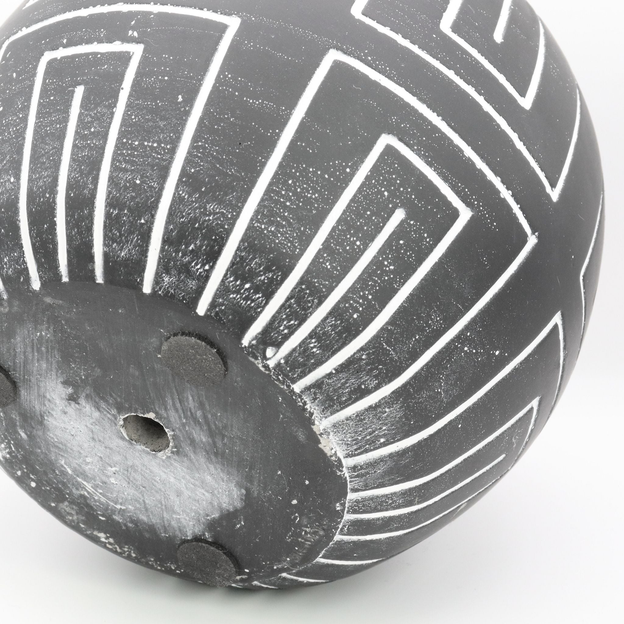 Black ceramic pot with geometric patterns on a white background