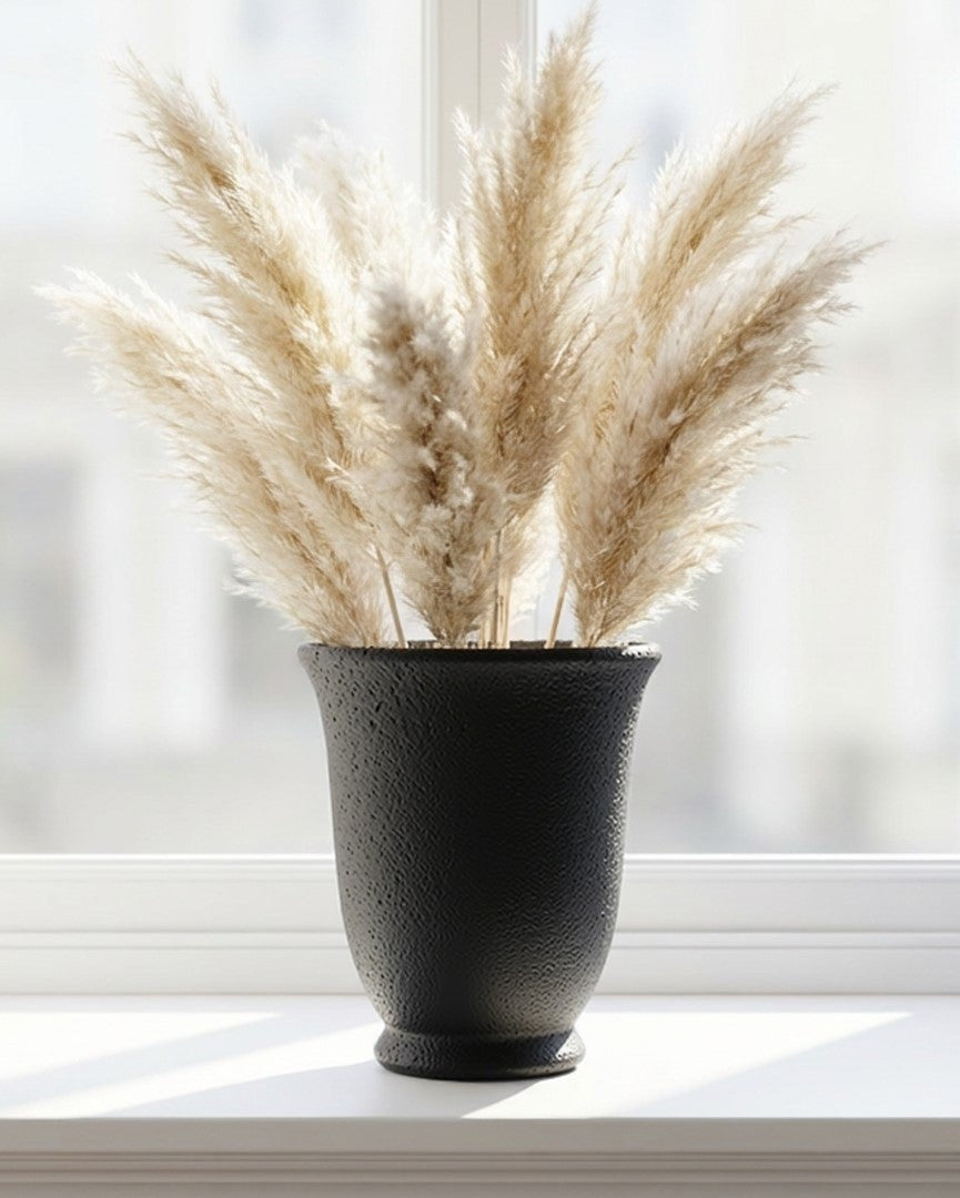 Textured black pot on a wooden surface with a light background