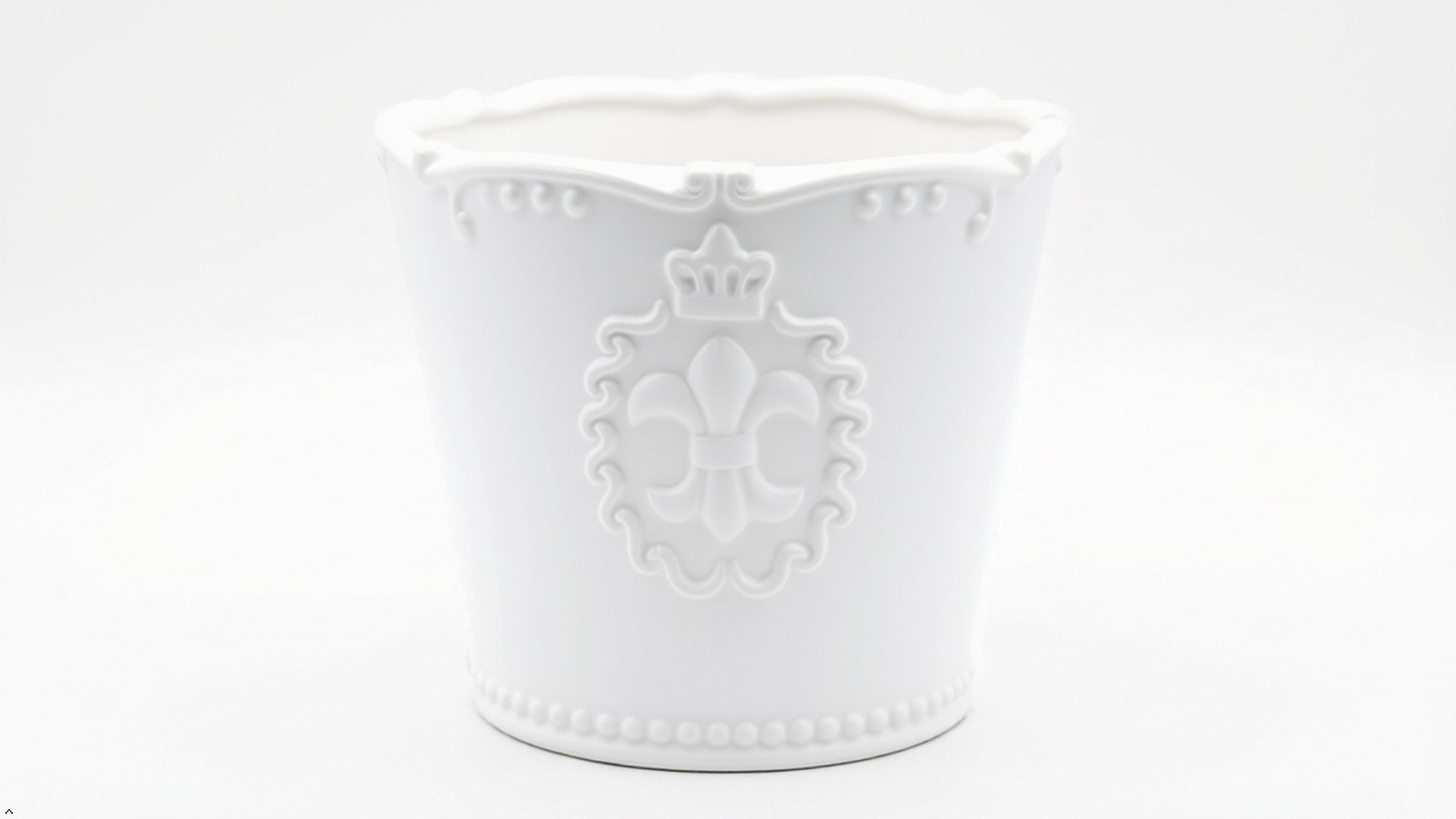 White decorative pot with intricate designs on a white background