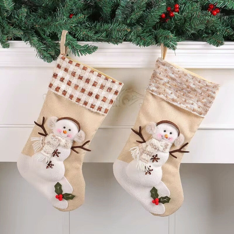 Two Christmas stockings with snowman designs hanging under a decorated tree.