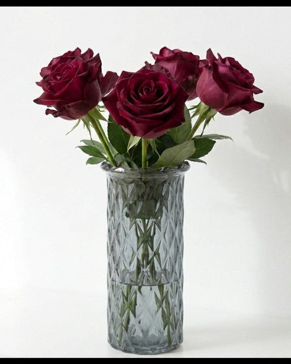 Grey glass vase with red roses on a white background