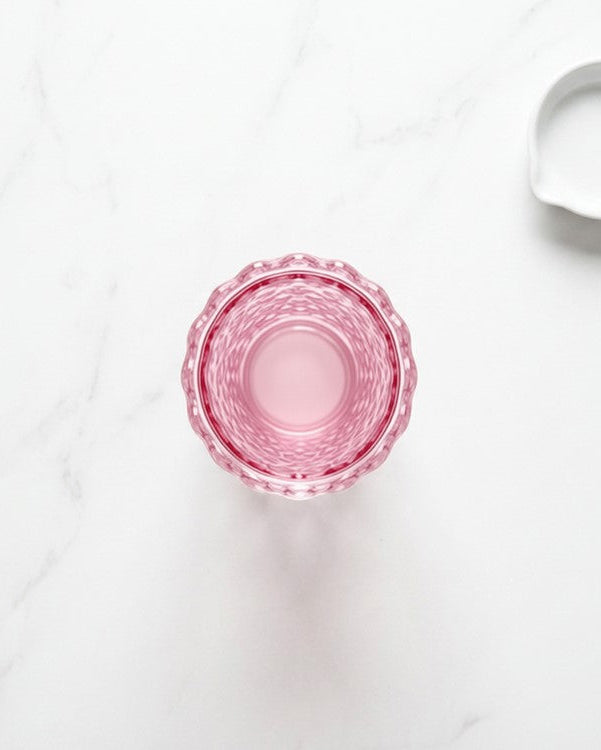 Pink glass on a white marble surface
