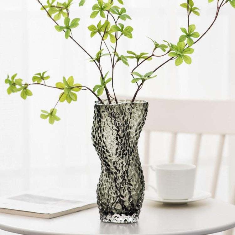 Wavy Textured Glass Vase with green flowers inside on a white table