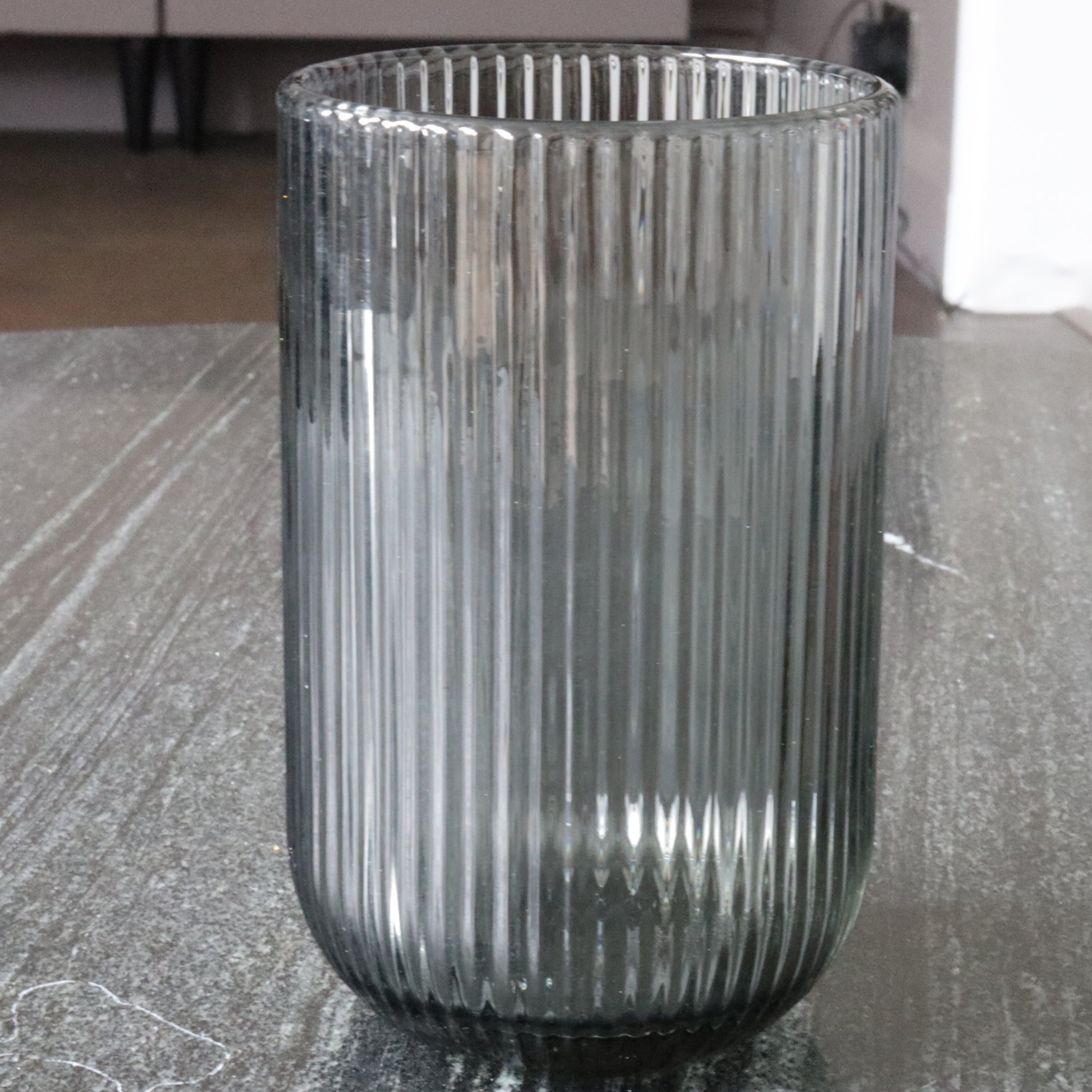 Ribbed glass vase on a textured surface