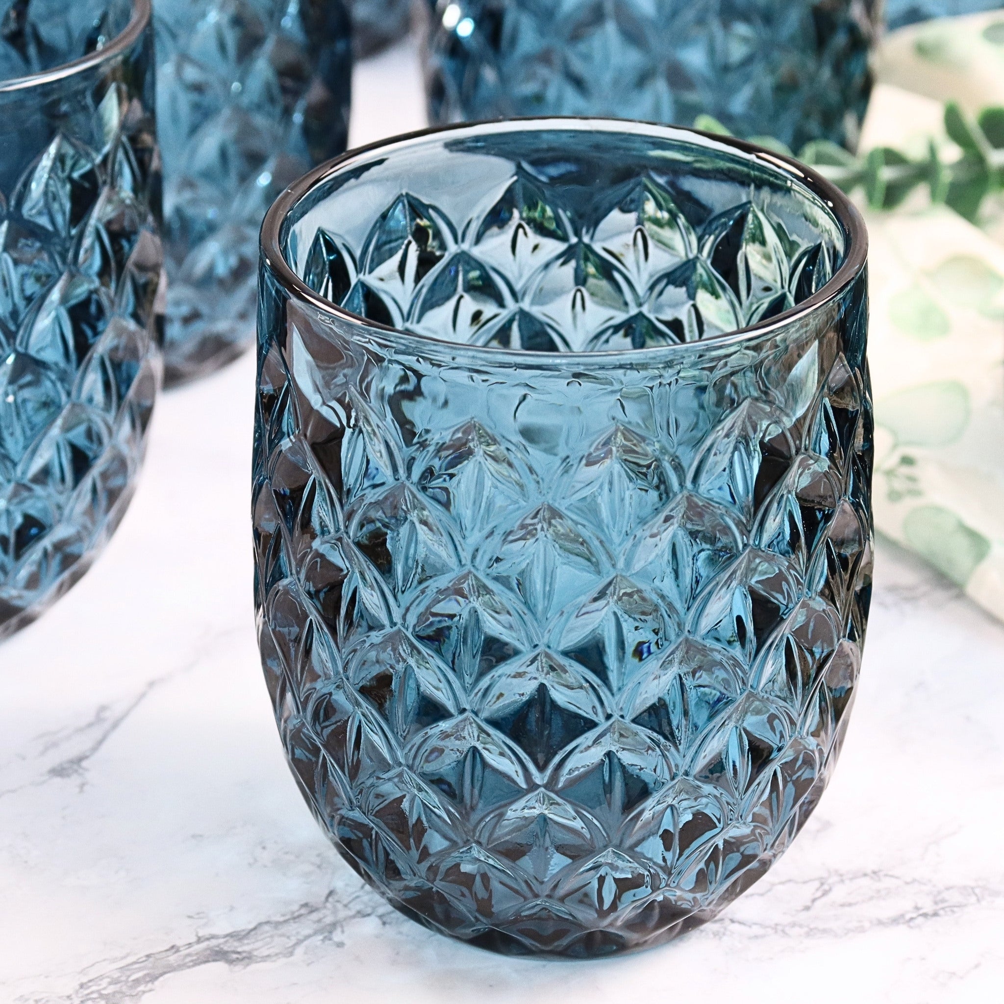 Blue textured glass tumbler on a marble surface