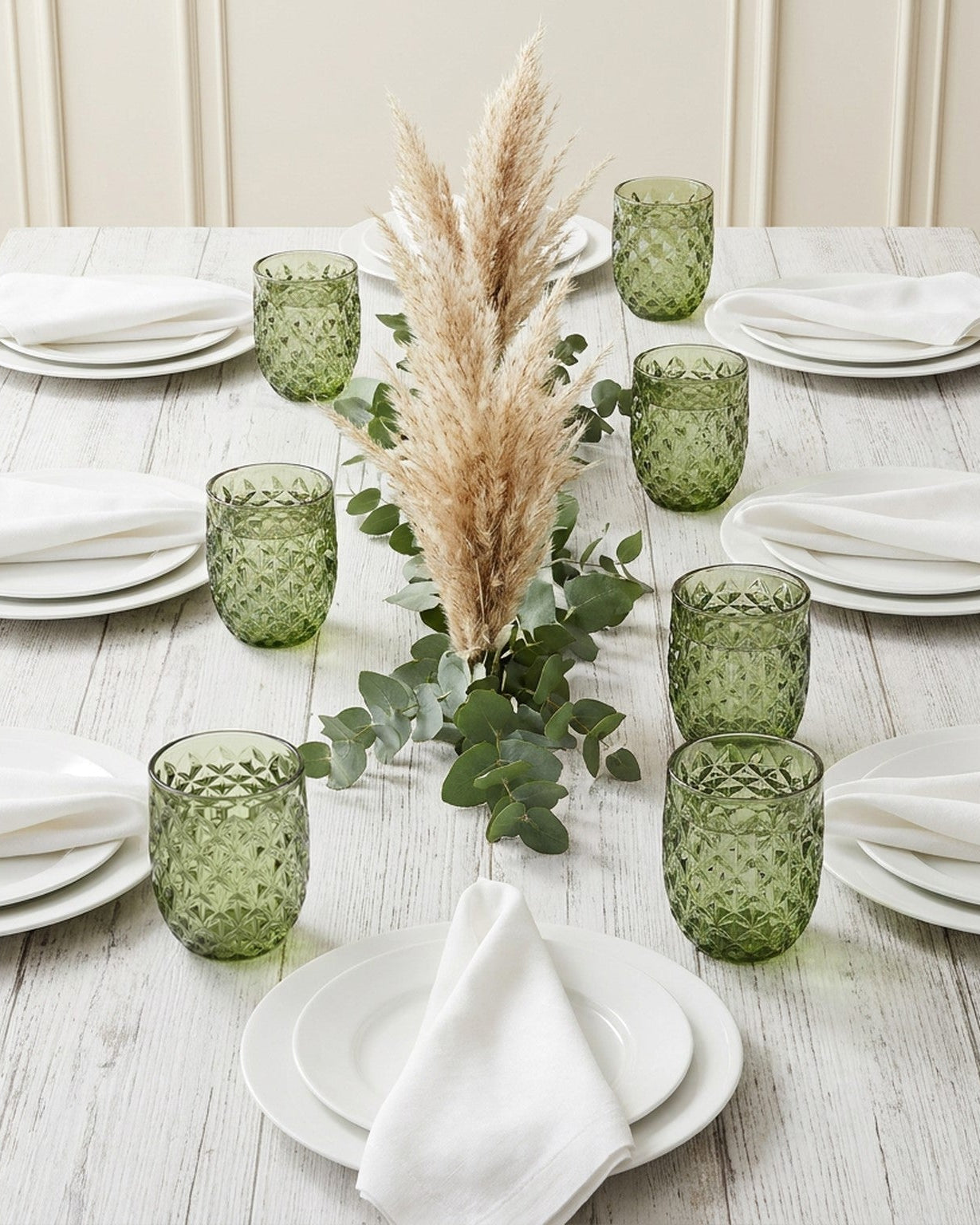 Set of six green patterned glass tumblers on a marble surface with a gray textured background.