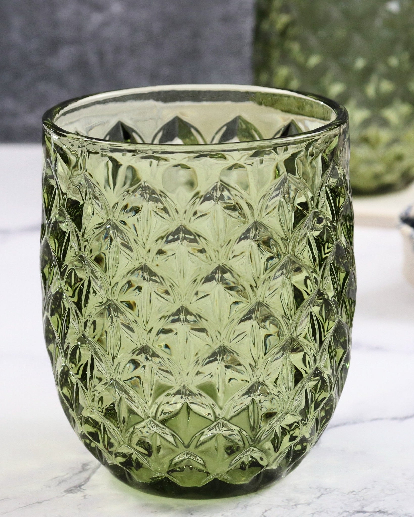 Green textured glass tumbler on a marble surface