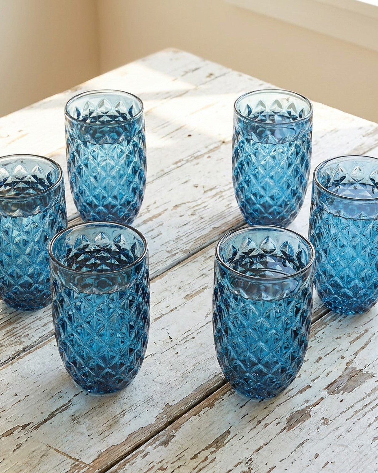 Set of blue textured glass tumblers on a wooden surface