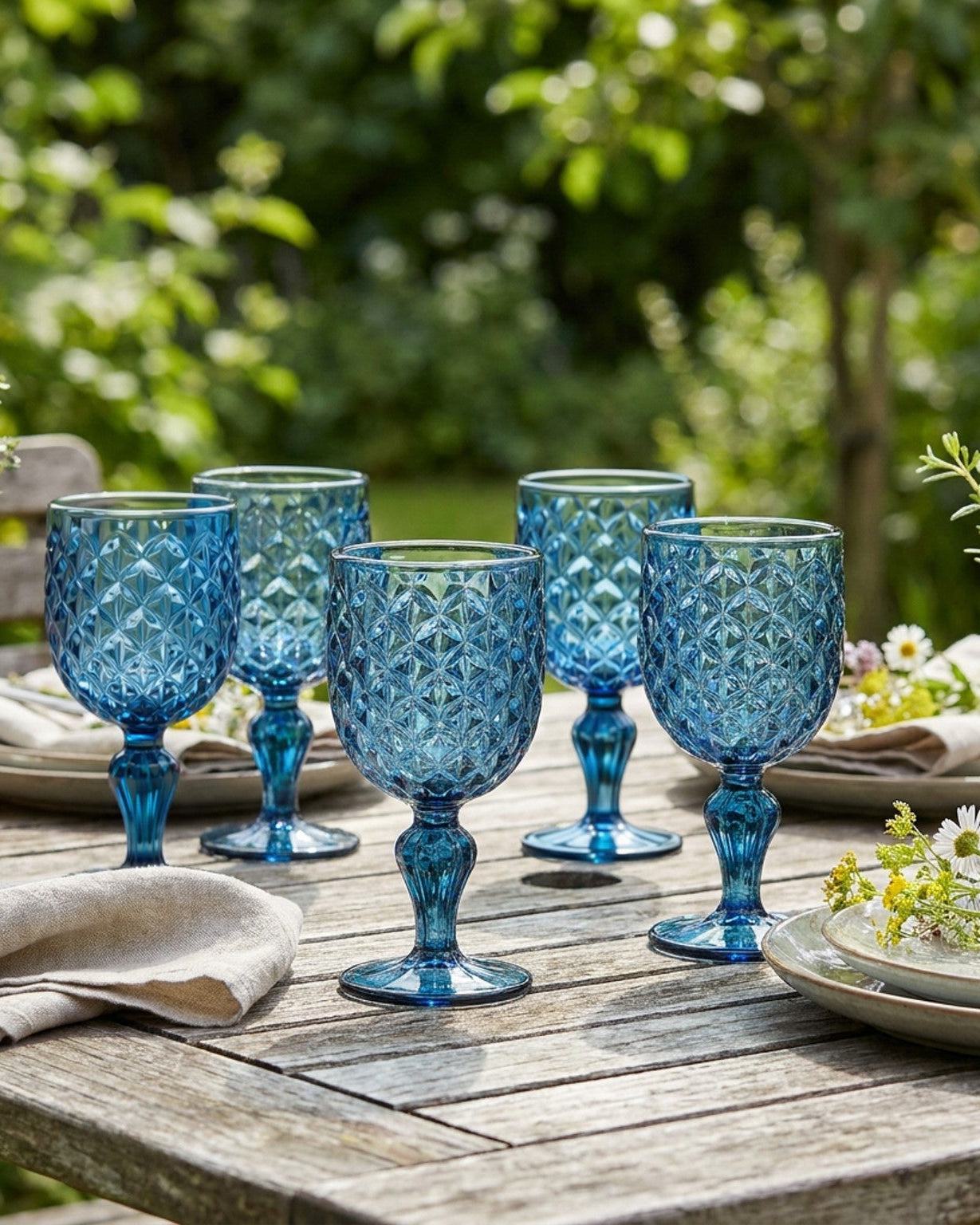 Set of blue glass goblets on a light gray surface
