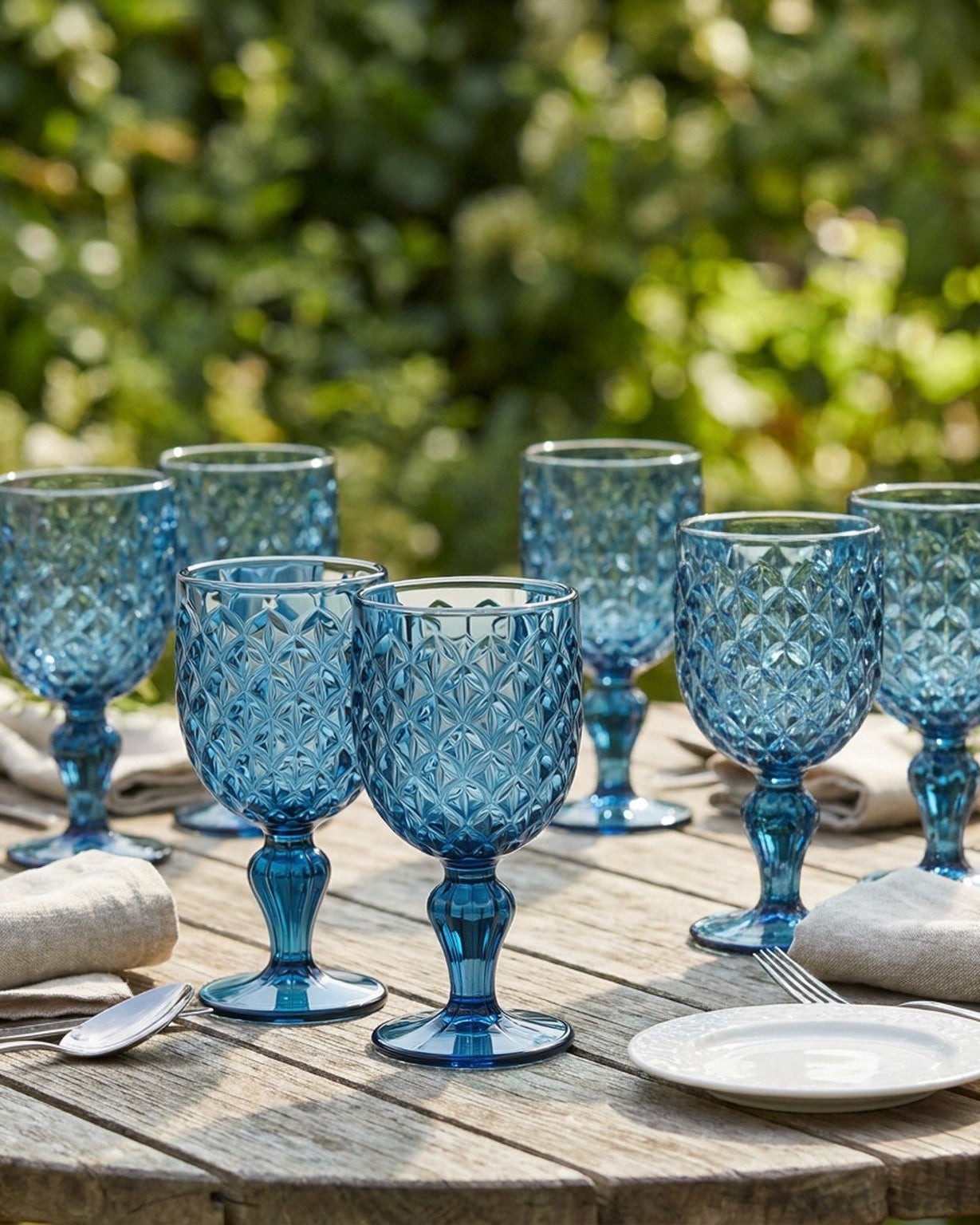 Set of 6 blue textured glass goblets on a light gray surface