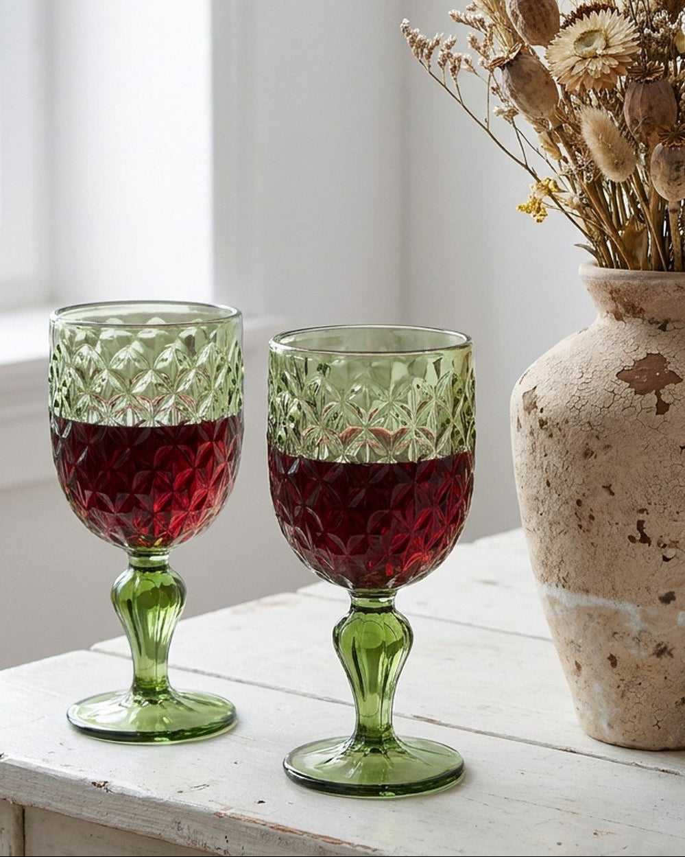 Green glass goblet with textured design on a marble surface