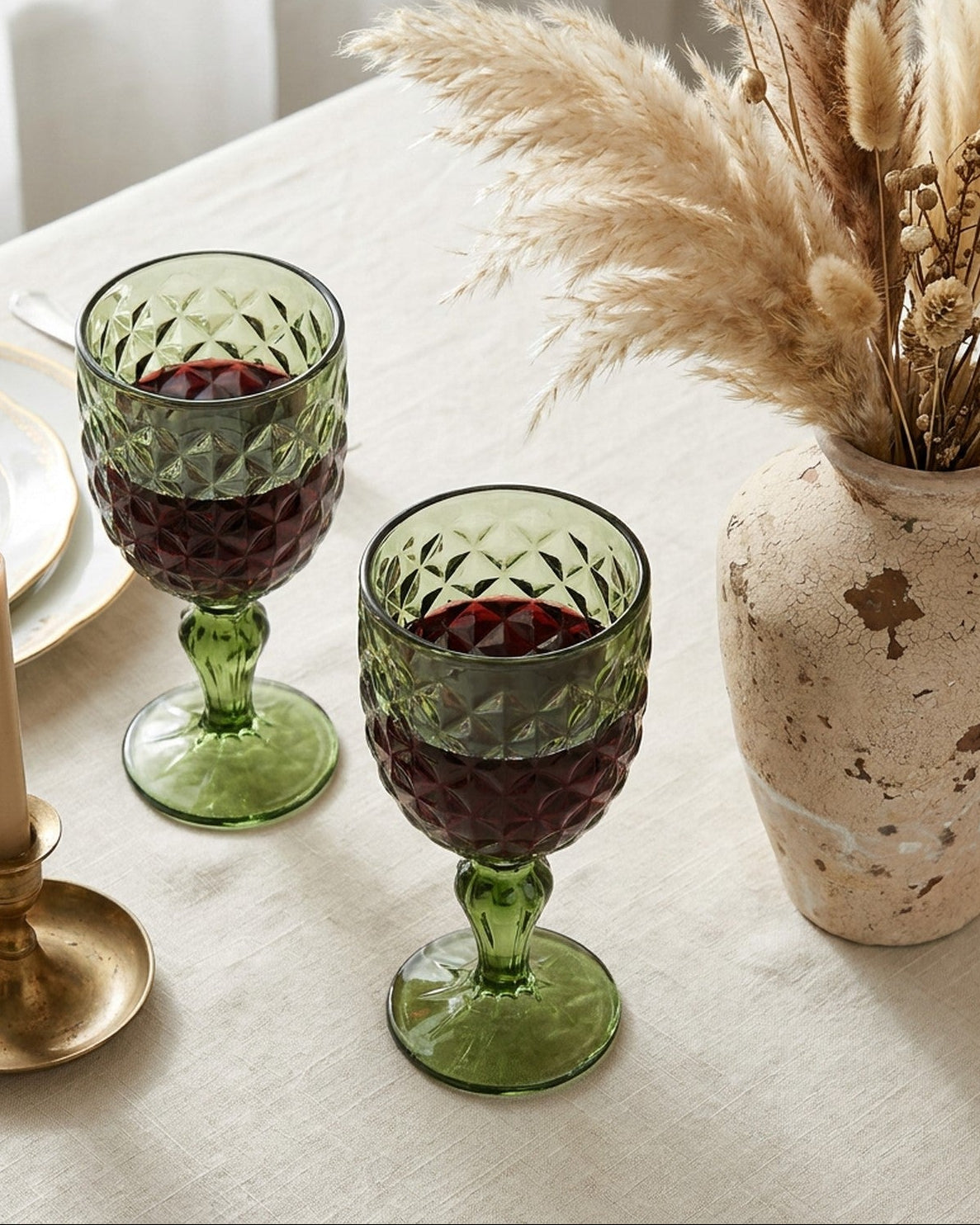 Green glass goblet with textured design on a marble surface