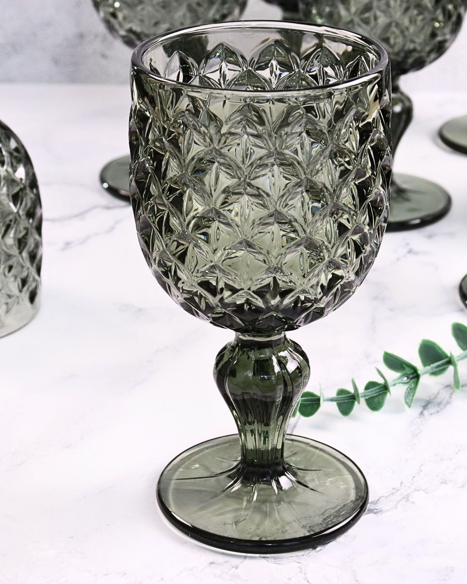 Decorative glass goblet with textured design on a white surface