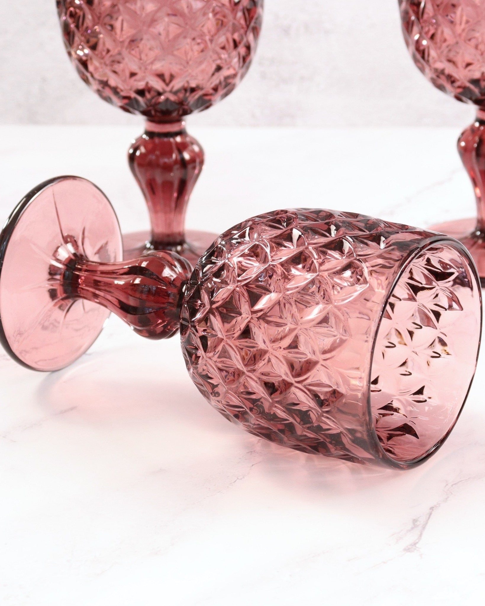 purple glass goblets with textured design on a white background