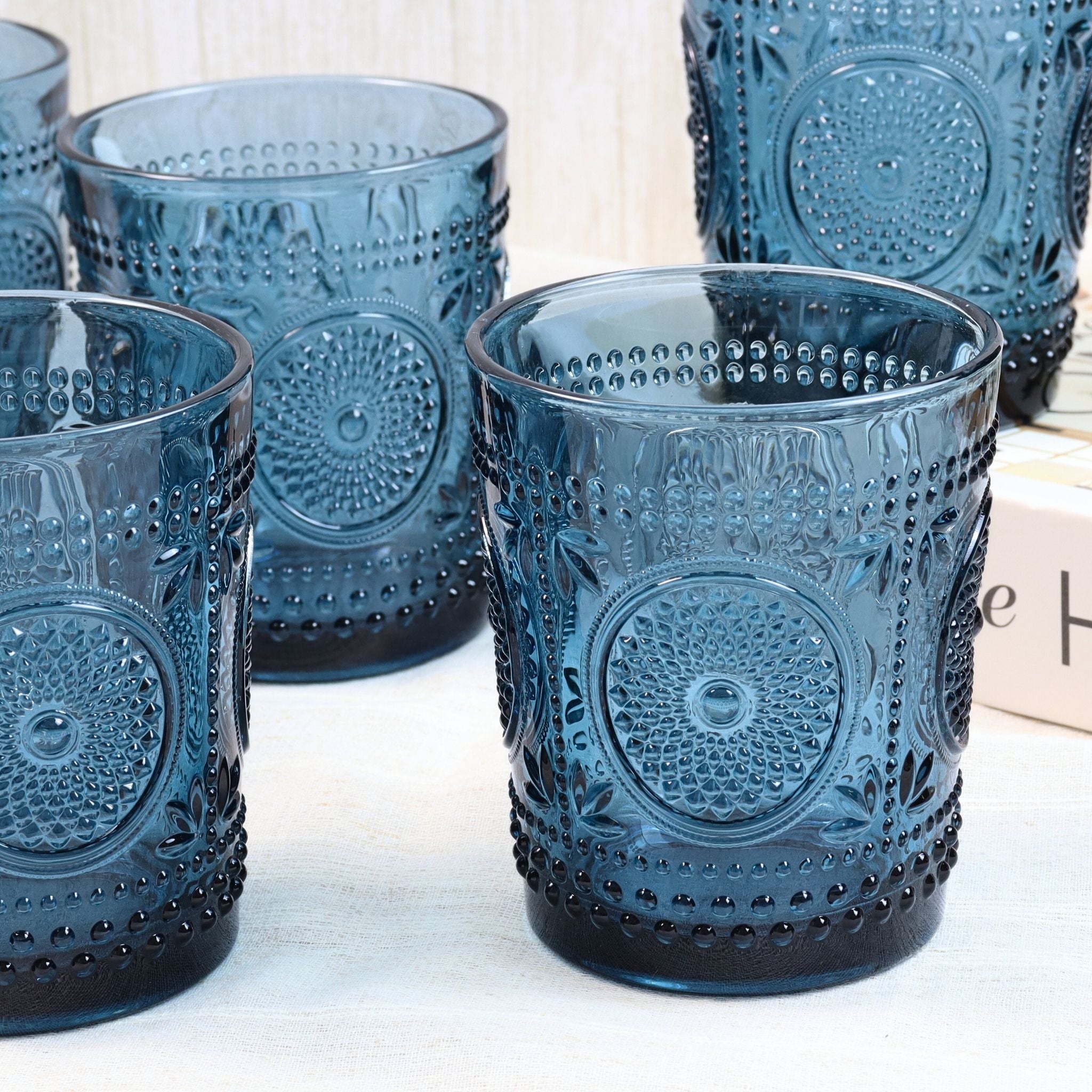 Set of blue textured glass tumblers on a light wooden surface