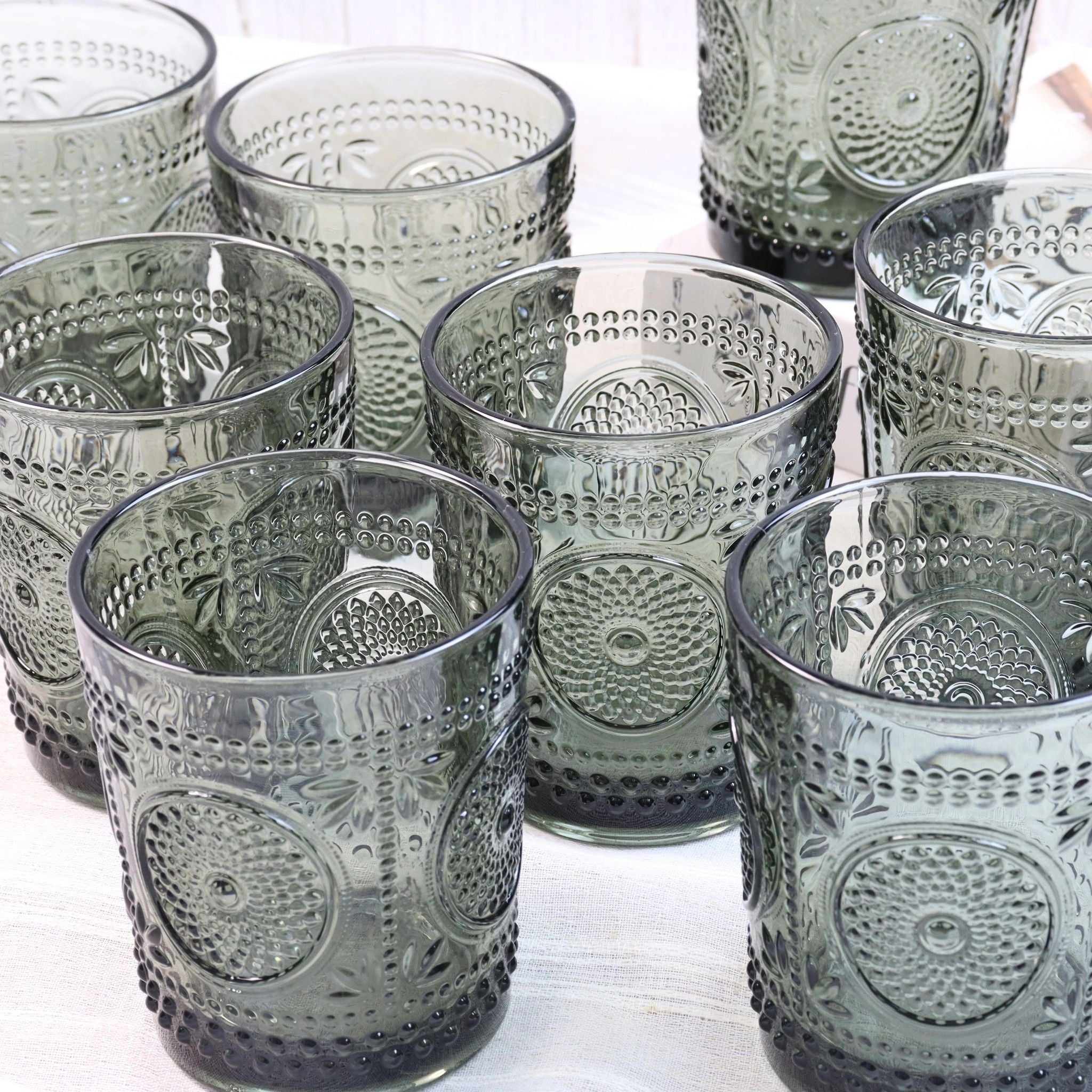 Set of textured glass tumblers on a white surface