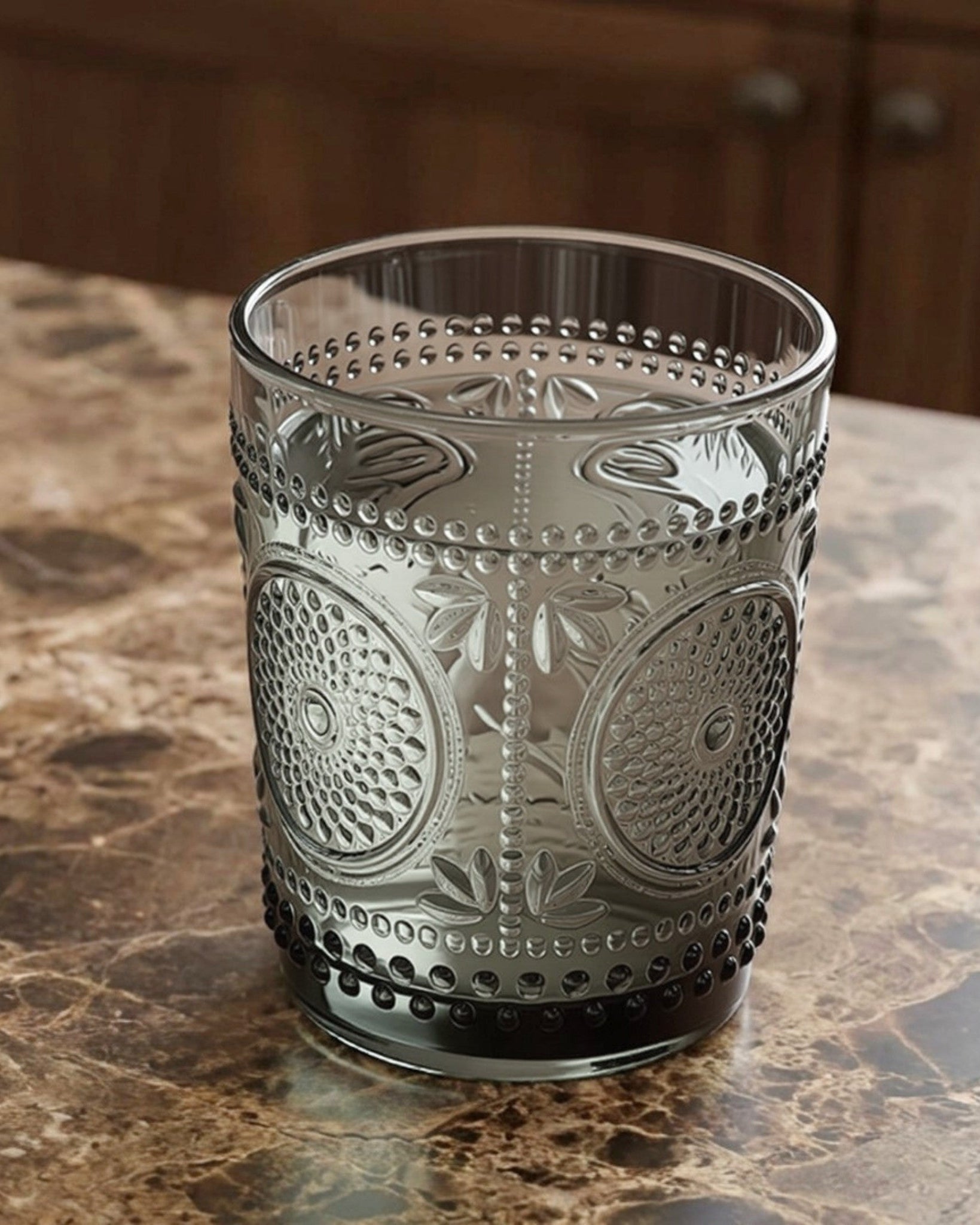 Set of eight patterned glass tumblers on a white surface